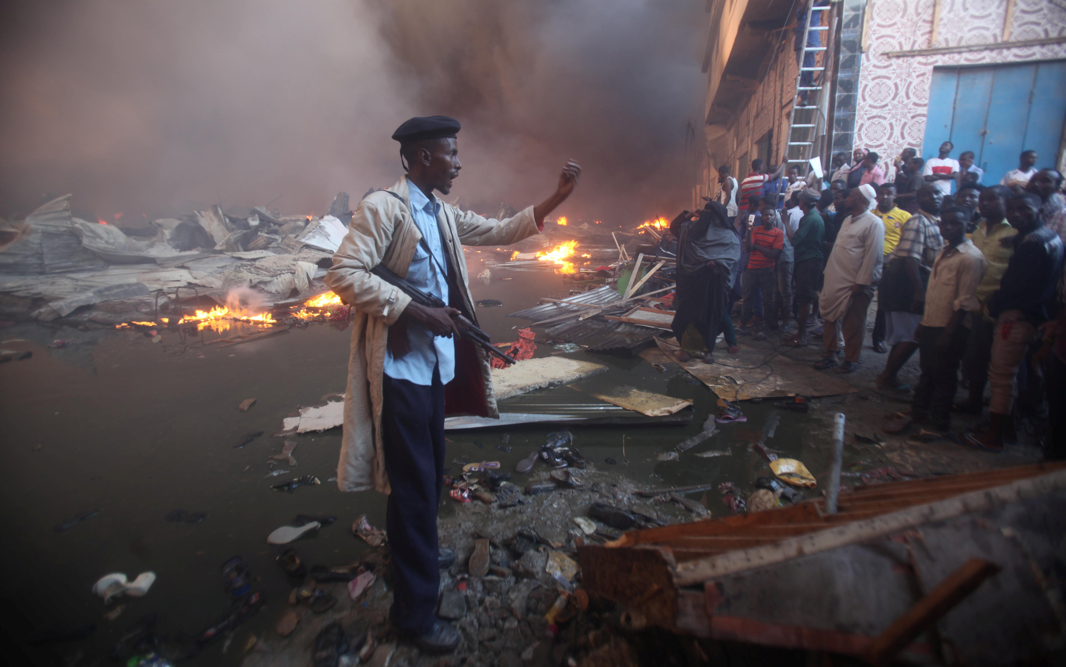رجل شرطة صومالى يوجه المواطنين للابتعاد عن مصدر الحريق فى السوق