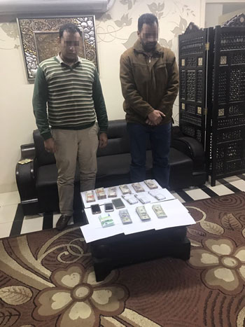 المتهمان بالاتجار بالعملة فى الشرابية وأمامهما الاموال المضبوطة