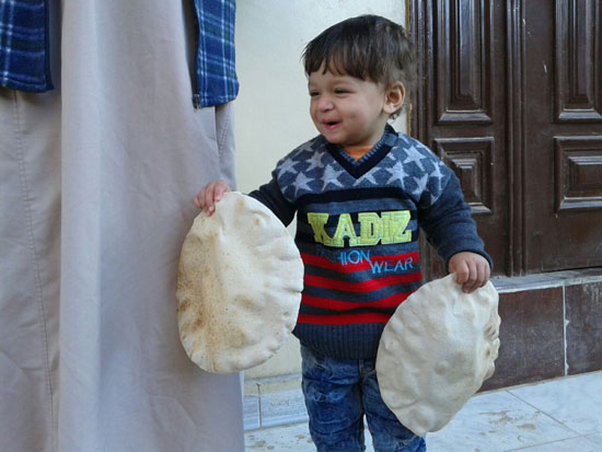 طفل يحمل الخبز