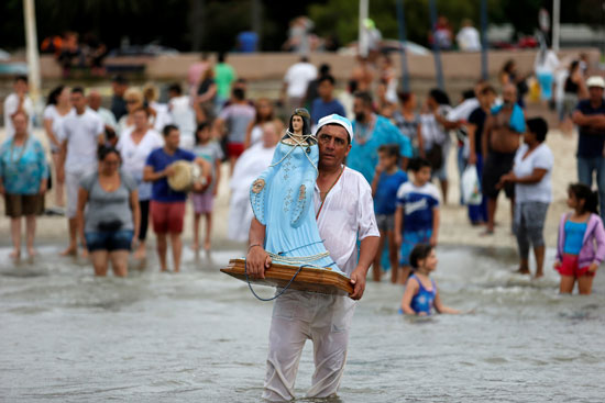 رجل يحمل مجسم لإله البحر يامانجا خلال الاحتفالات فى أوروجواى