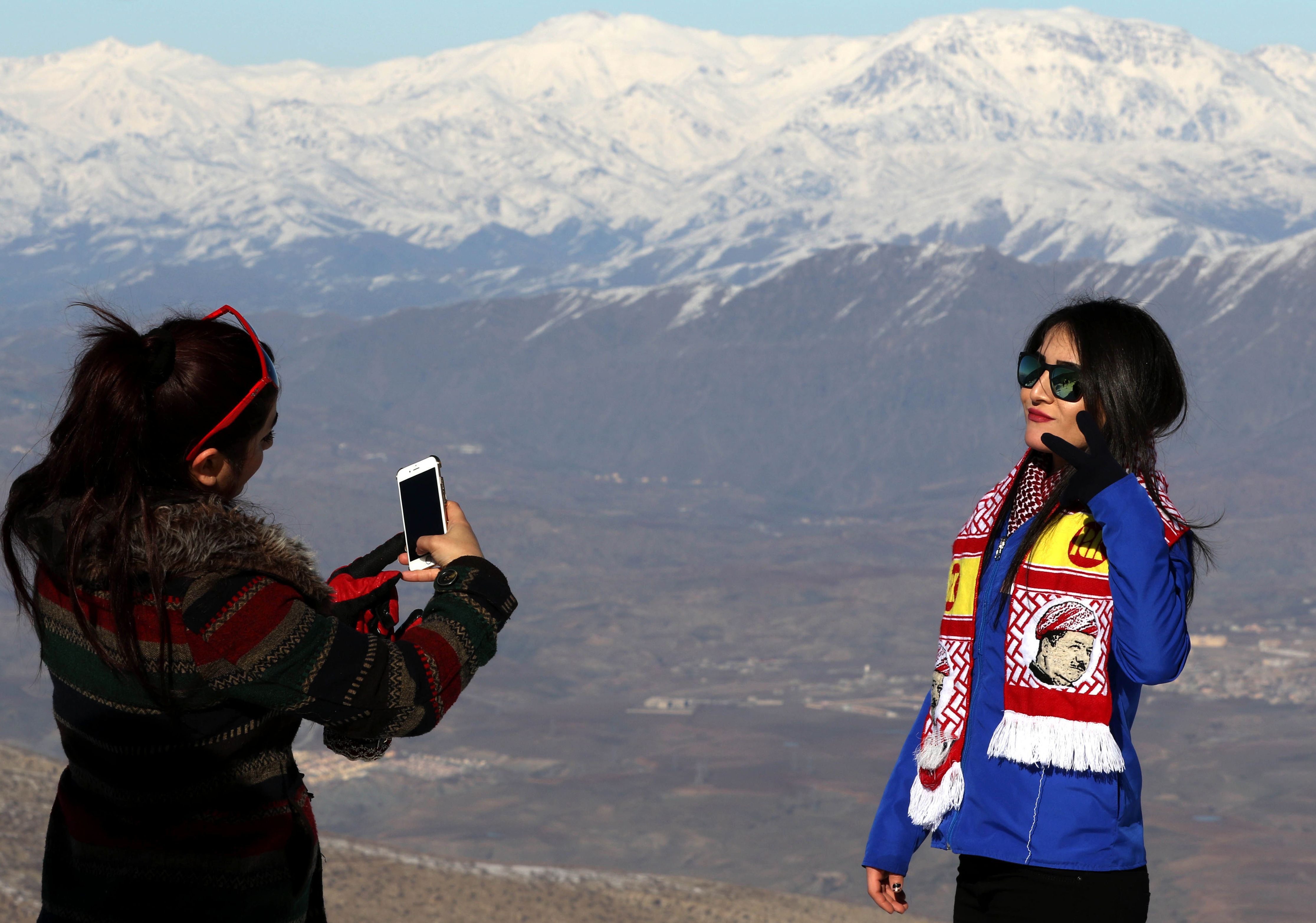 فتيات كرديات يلتقطن صور تذكارية أعلى جبل كورك