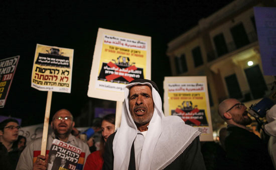 مواطن من عرب اسرائيل يقف وسط المحتجين
