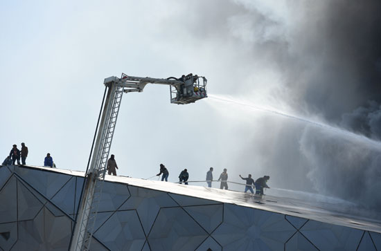  رجال الإطفاء يحاولون إخماد حريق المركز الثقافى