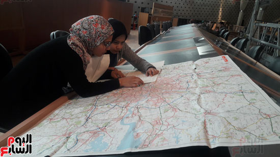 الطلاب يدرسون الخرائط بالمكتبة