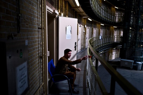 أحد اللاجئين يرتشف الشاى أمام غرفته بالسجن