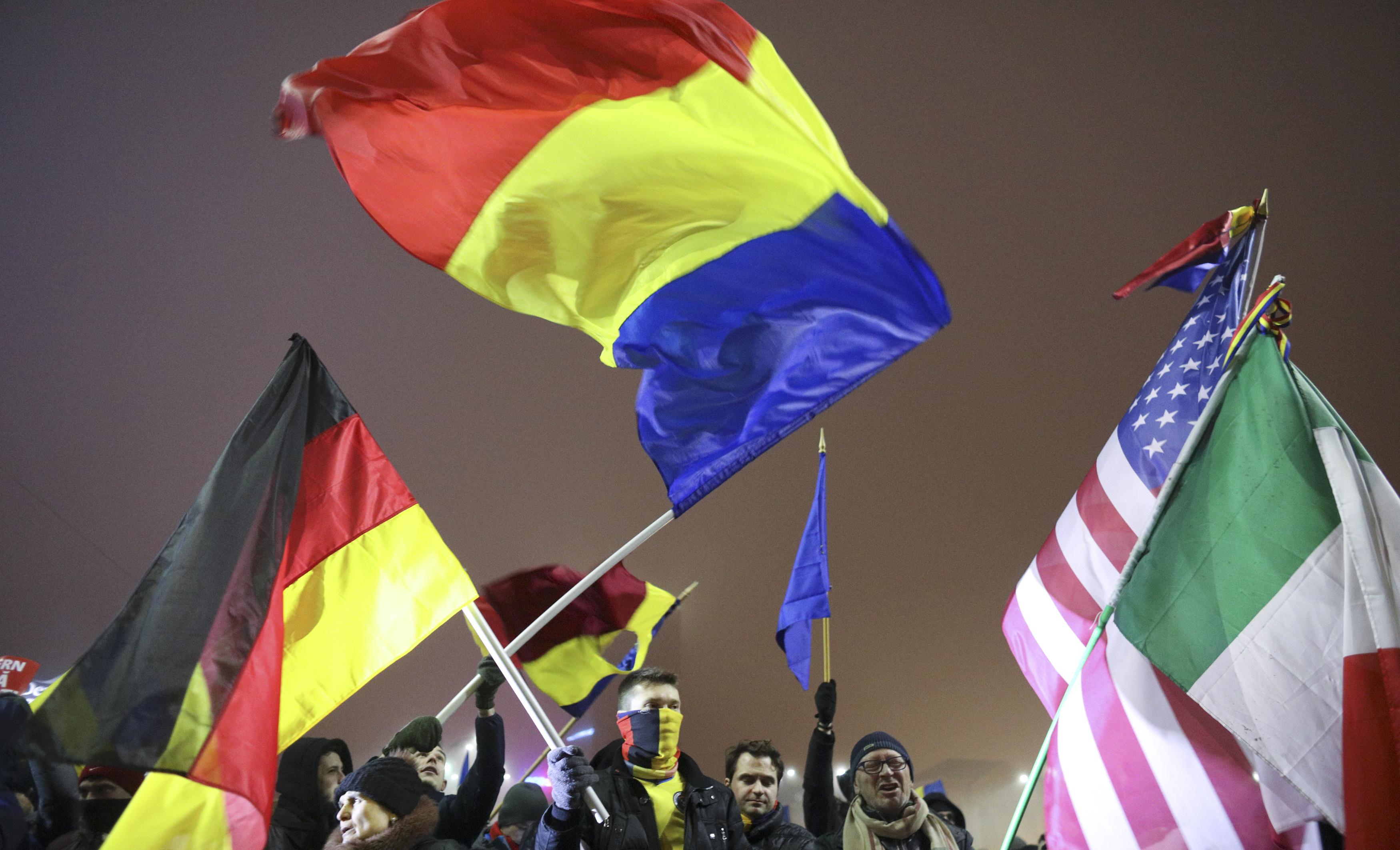 أعلام إيطاليا وألمانيا وأمريكا وسط تظاهرات رومانيا