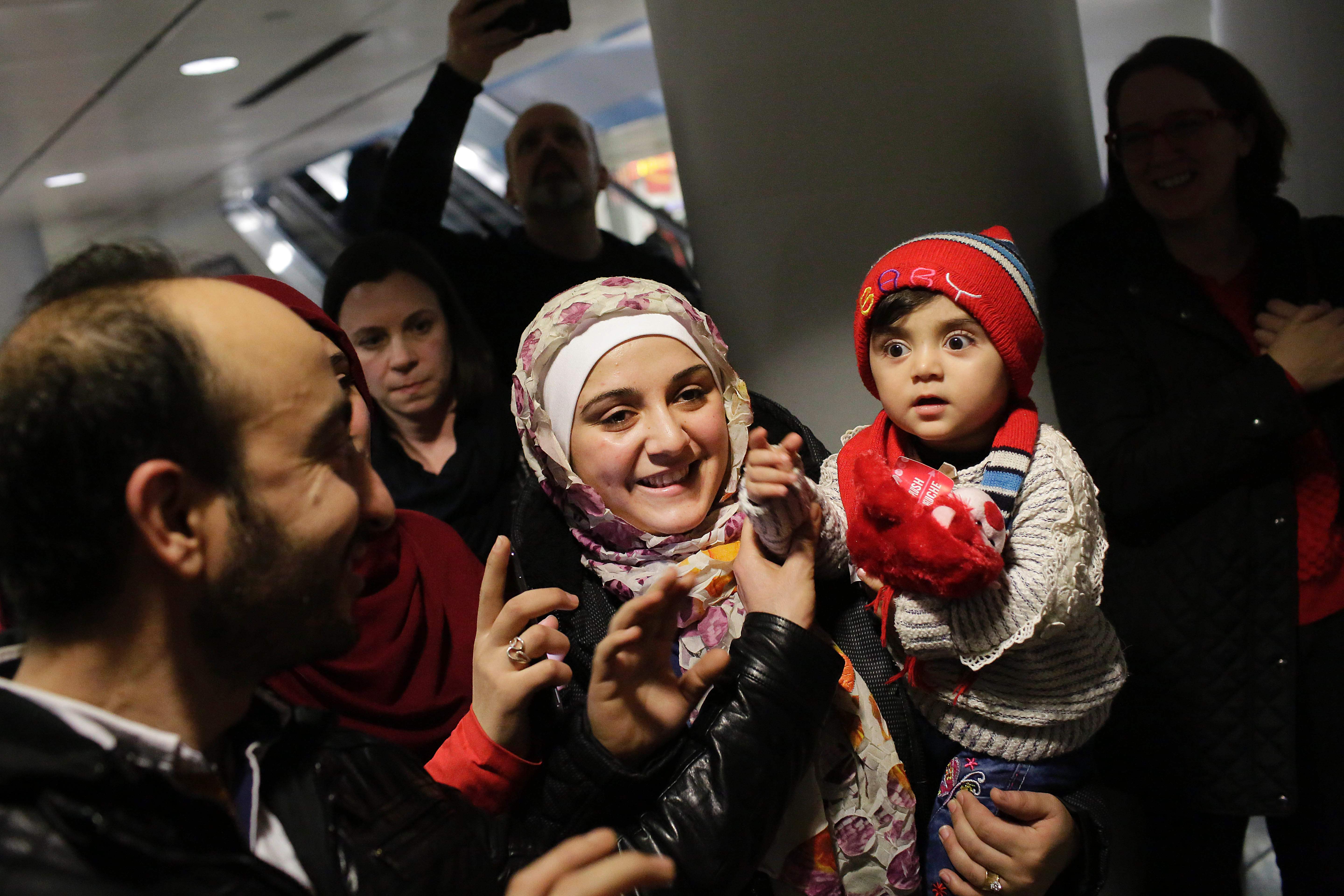 اللاجئة السورية تحمل أبنتها خلال مغادرة مطار أوهير الدولى