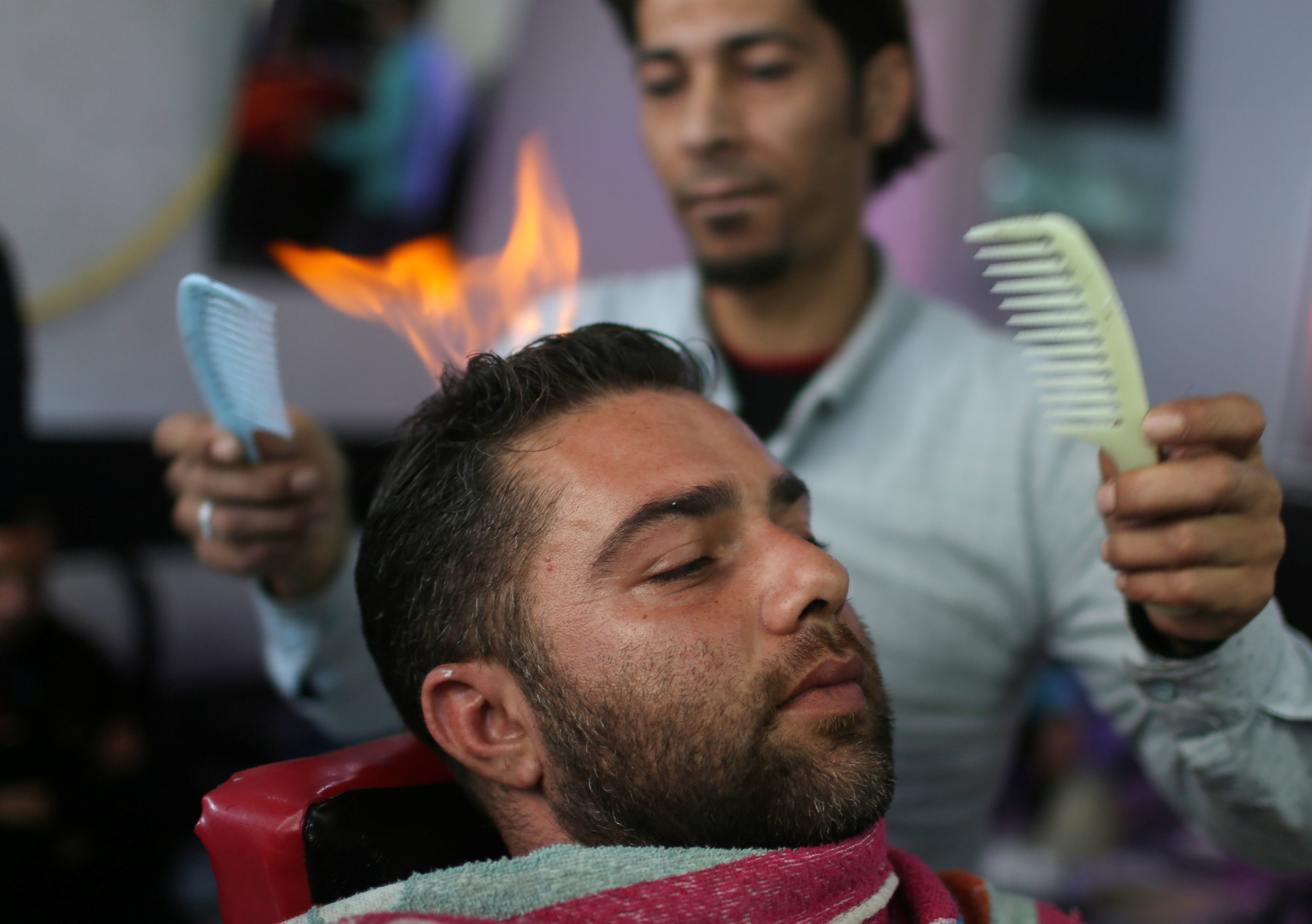 حلاق فلسطينى يستخدم النار فى فرد الشعر