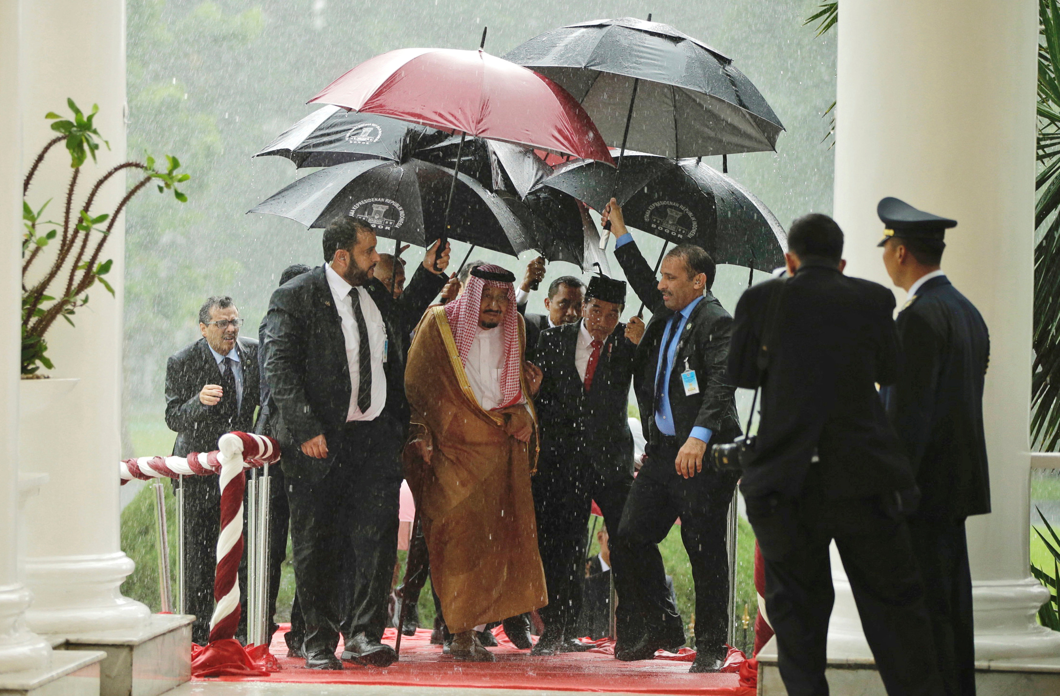 الملك سلمان يحاول الاختباء من الأمطار - رويترز