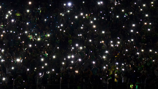 جماهير  كرة القدم فى كوبا سوداميريكانا يستخدمون هواتفهم للإضاءة بعد انقطاع للتيار الكهربائي خلال مباراة