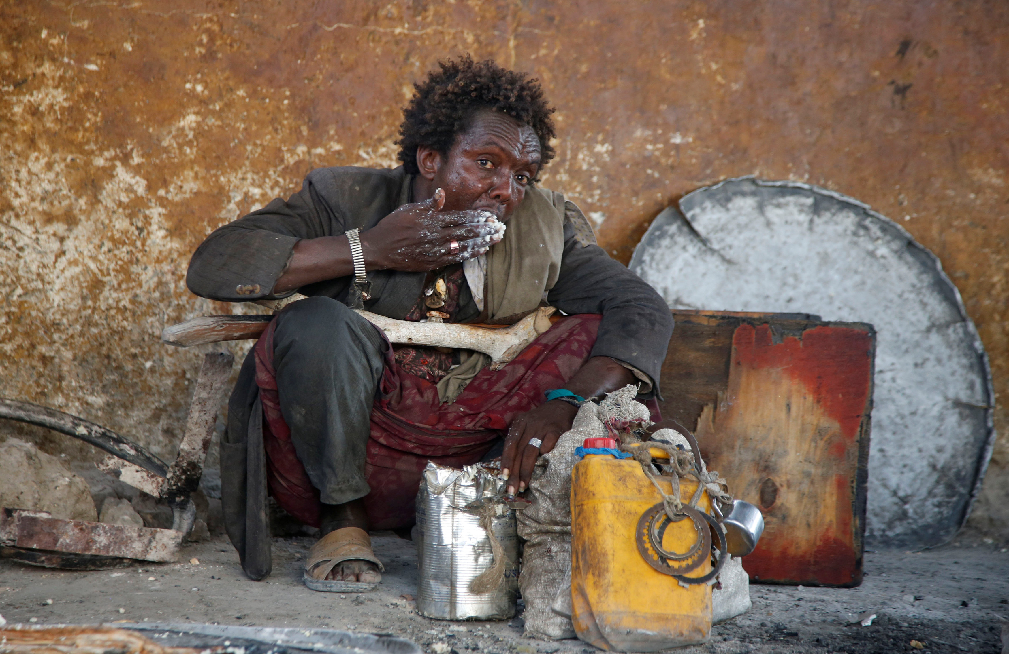 رجل صومالى  يأكل وجبة ذرة من برنامج التغذية برنامج الأغذية العالى