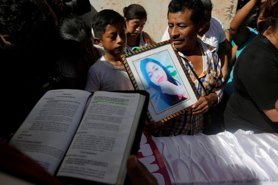 تشييع جثمان إحدى الفتيات وأحد اقاربها يرفع صورتها