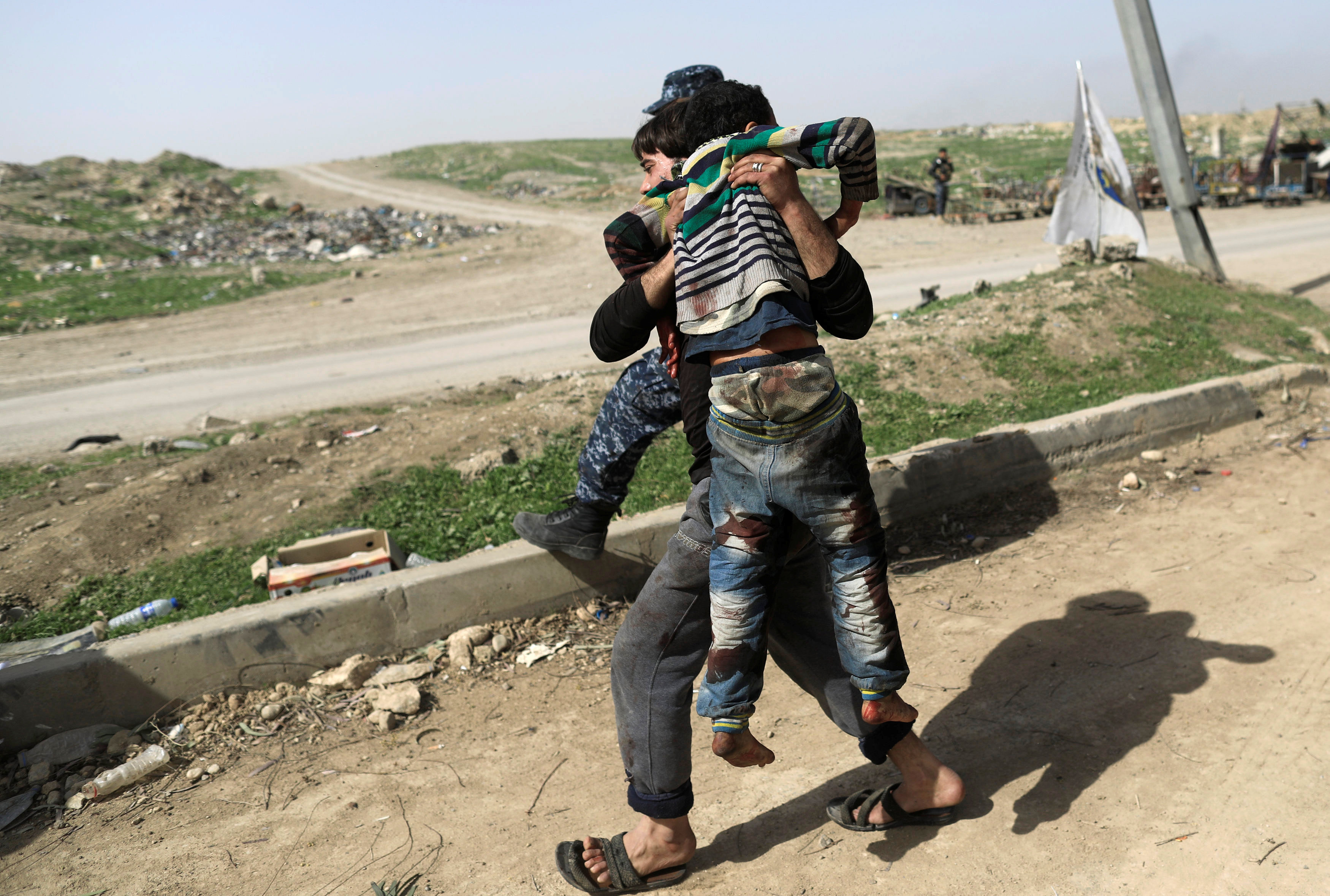 رجل يحمل أحد المصابين فى انفجار الموصل