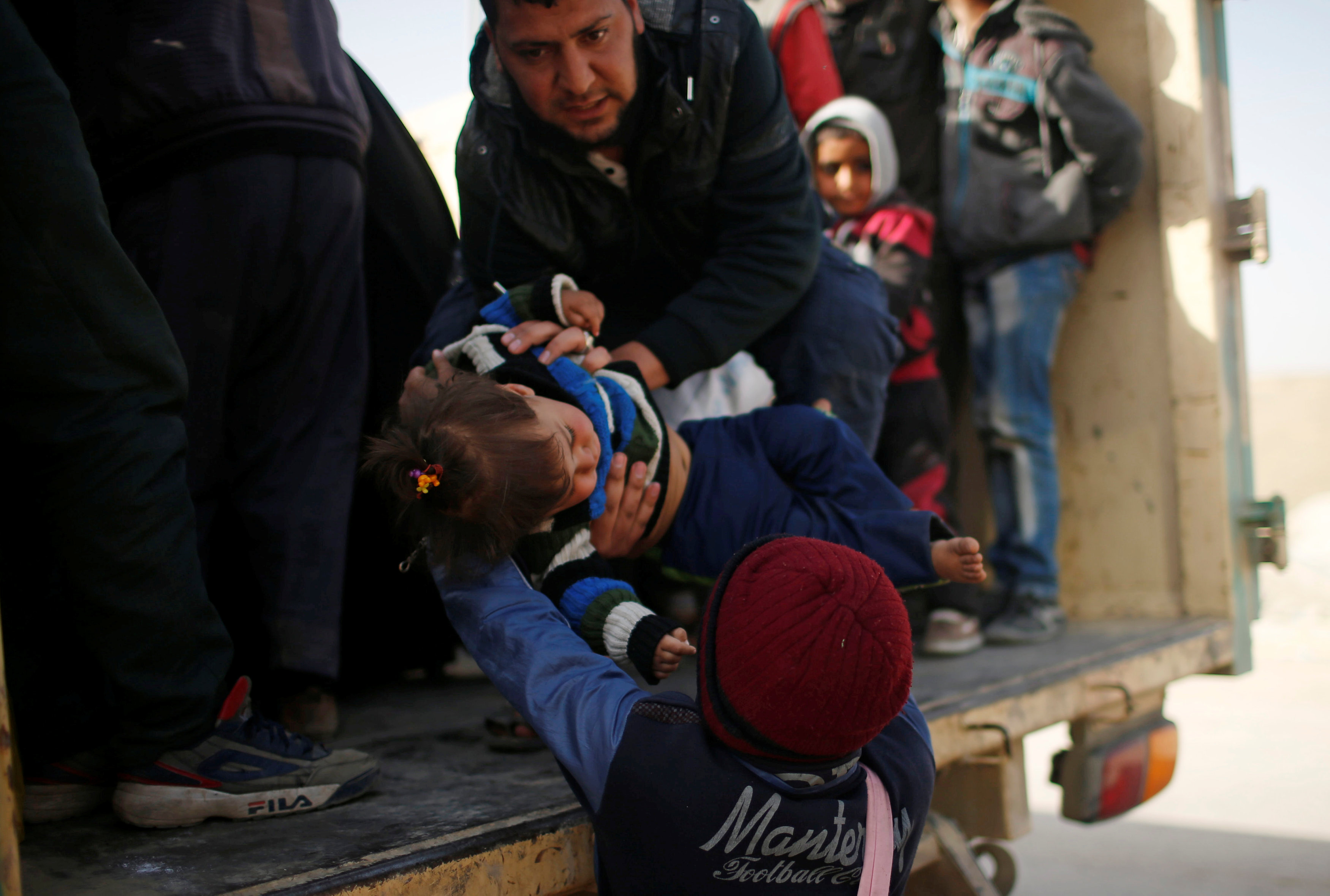 النازحون العراقيون يحملون الأطفال على السيارات للهرب من داعش