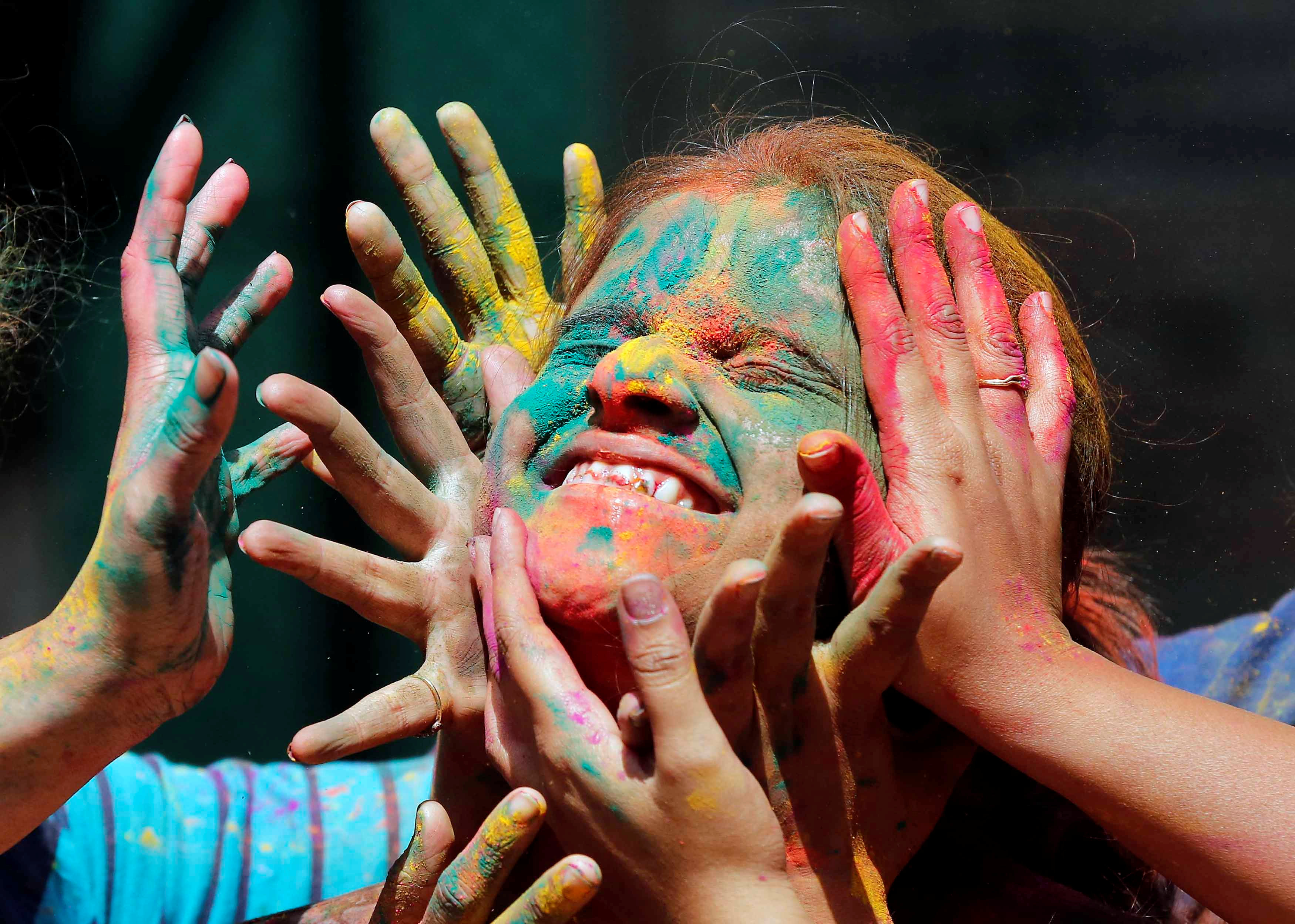 أطفال يرشون الألوان على وجه صديقتهم فى احتفالات الهند