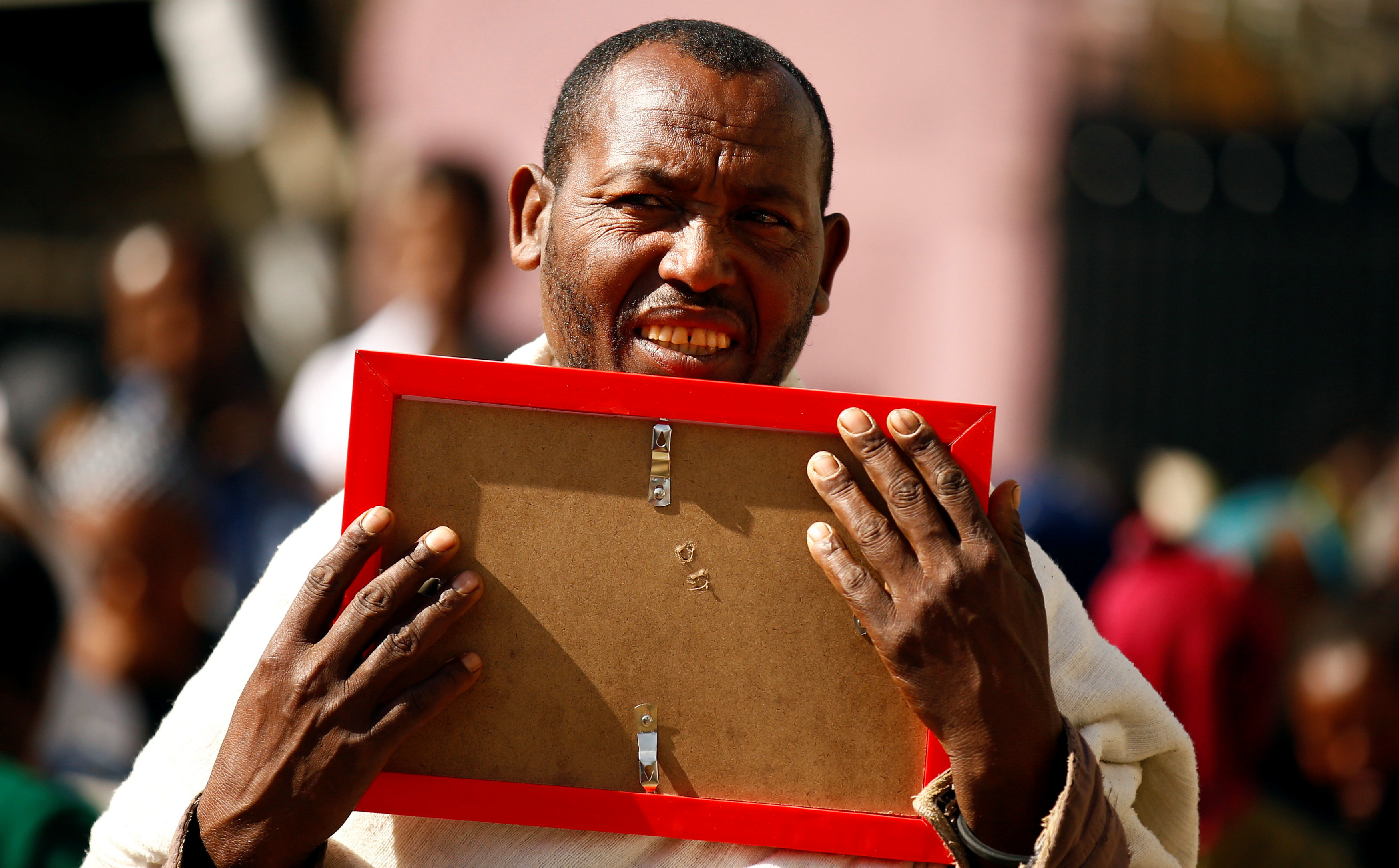 رجل يحتضن صورة أحد ضحايا انهيار مكب للنفايات فى إثيوبيا