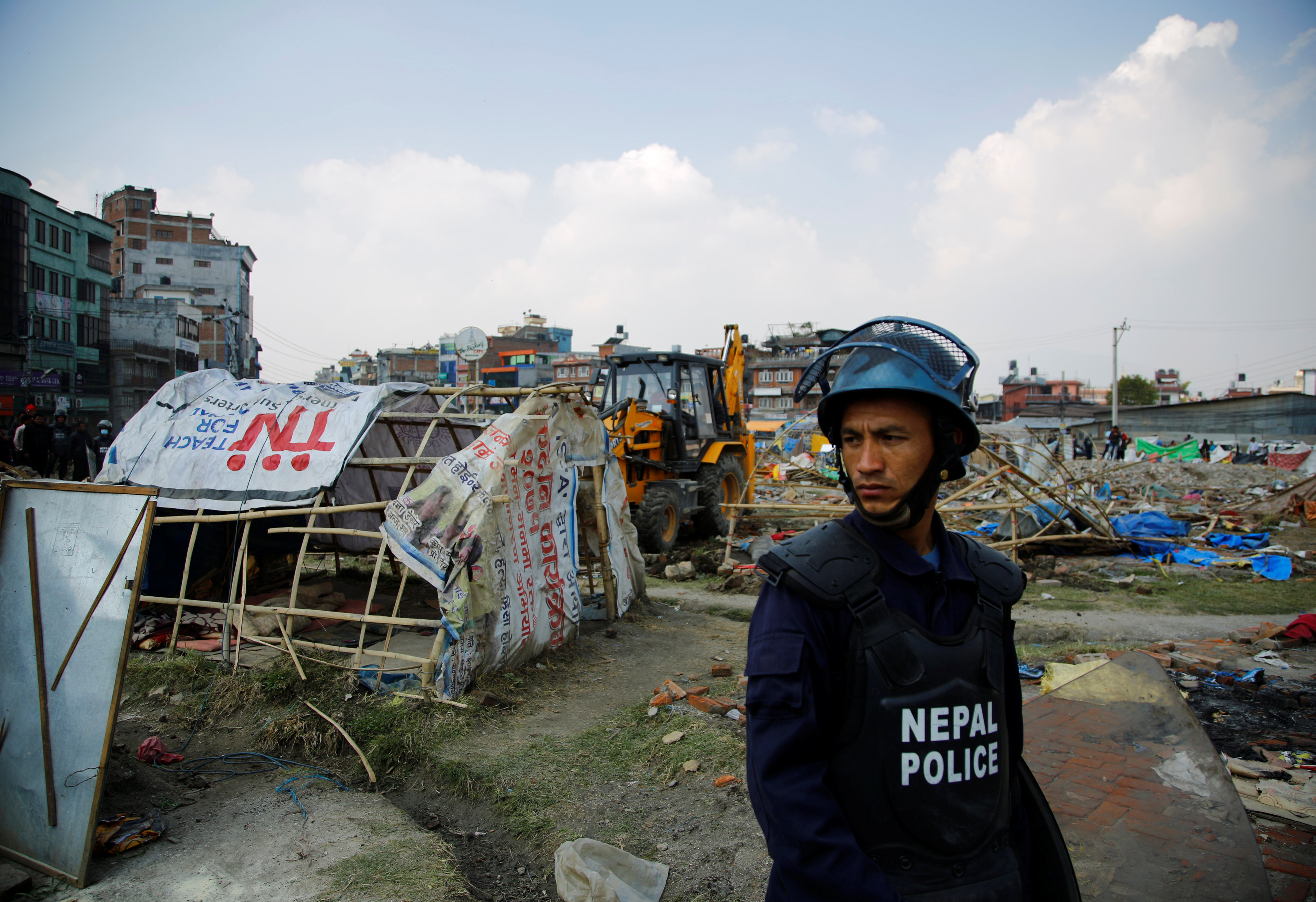 شرطى نيبالى يقف خلال هدم مخيمات المشردين من الزلزال