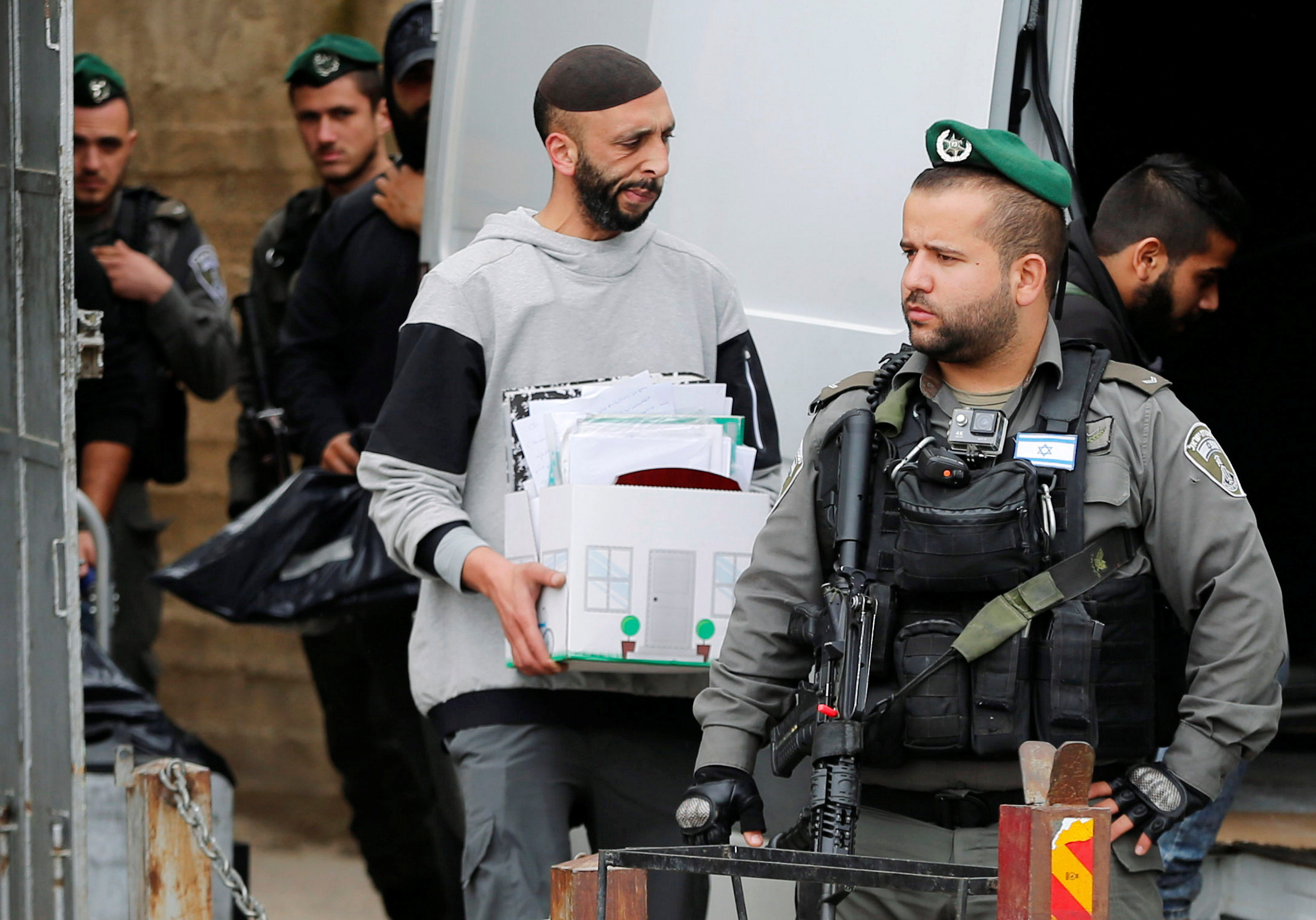 ضباط الاحتلال يحملون الأوراق من مكتب الخرائط الفلسطينية