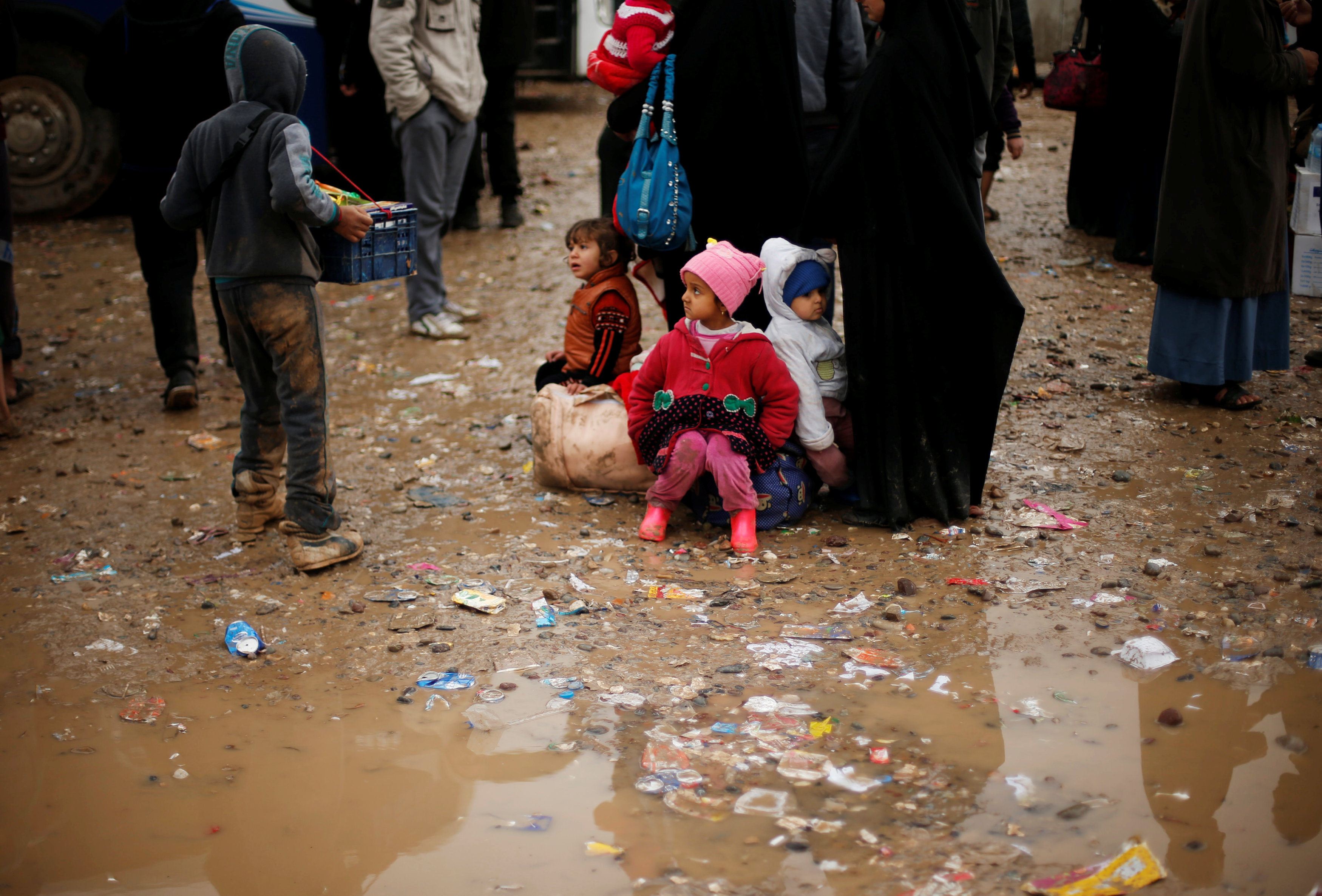 أطفال رضع يتحدون المطر للوصول إلى المخيمات