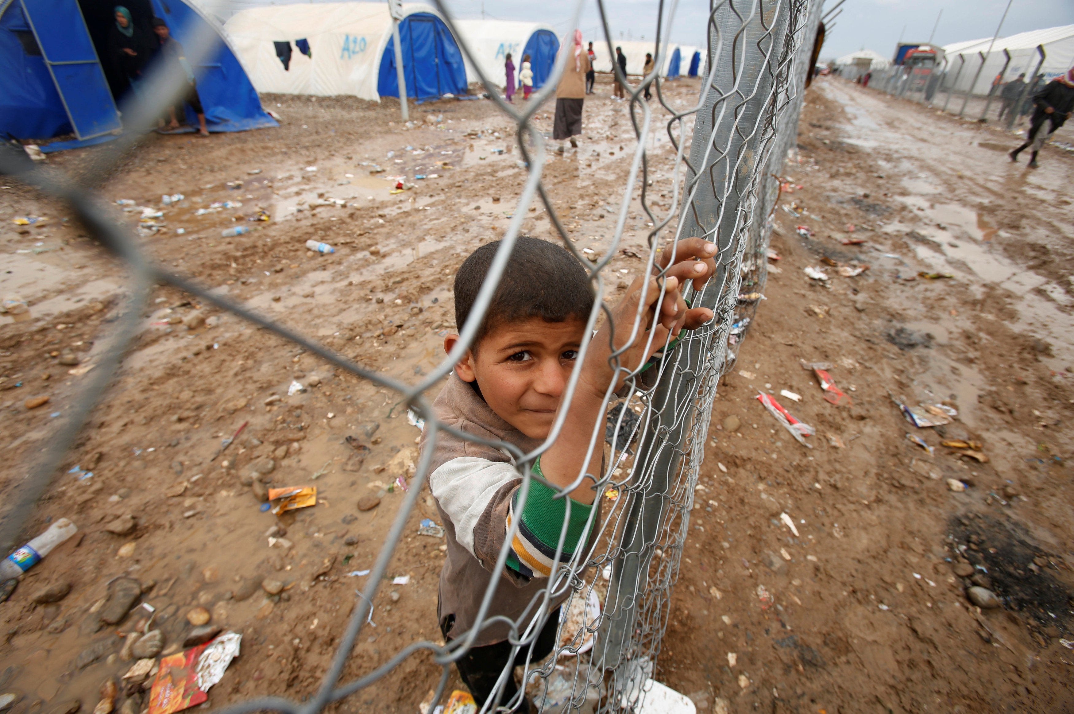 طفل يقف على حدود أحد المخيمات