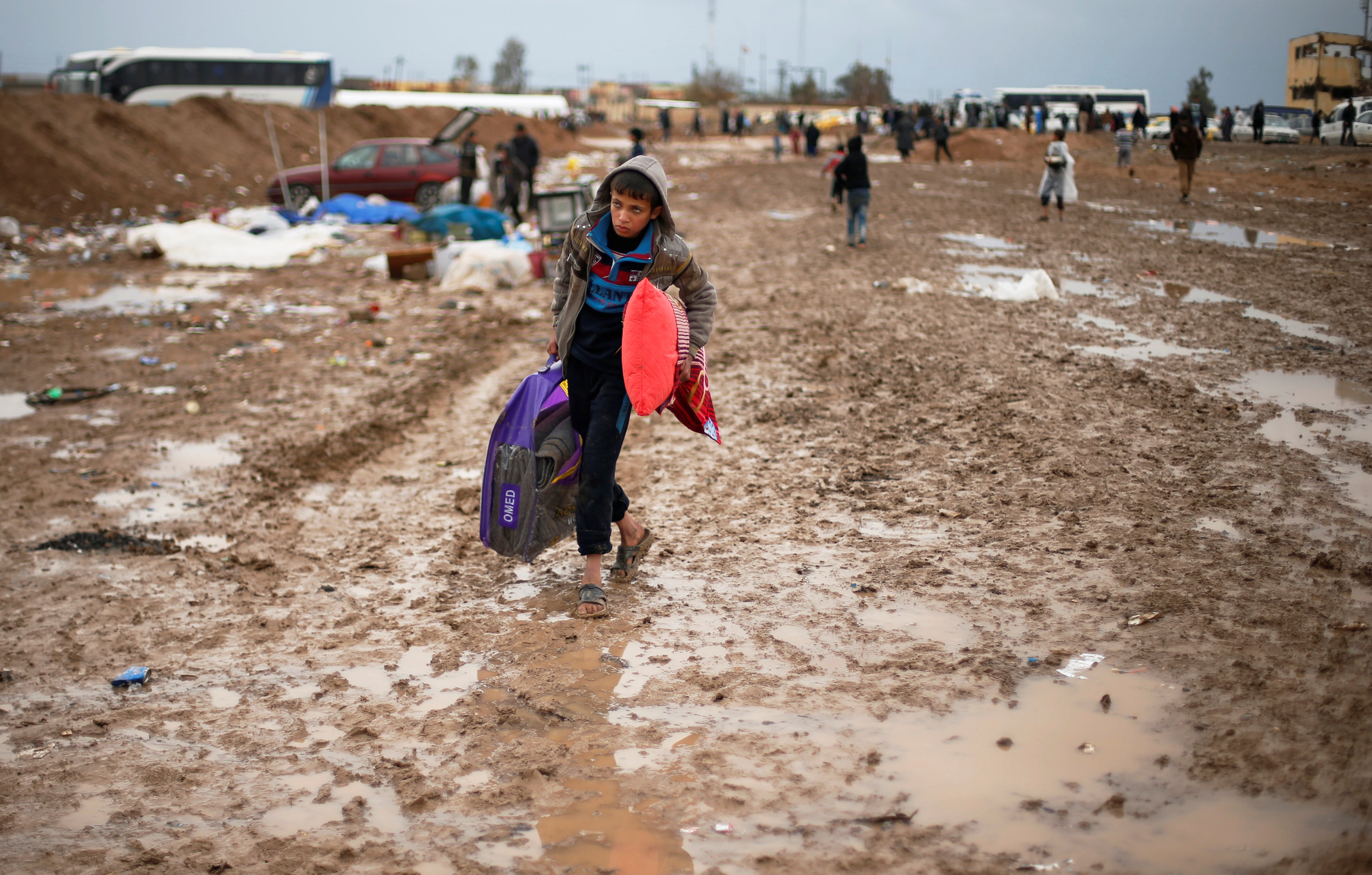 طفل يتحدى المطر متوجهها إلى مخيمات النازحين