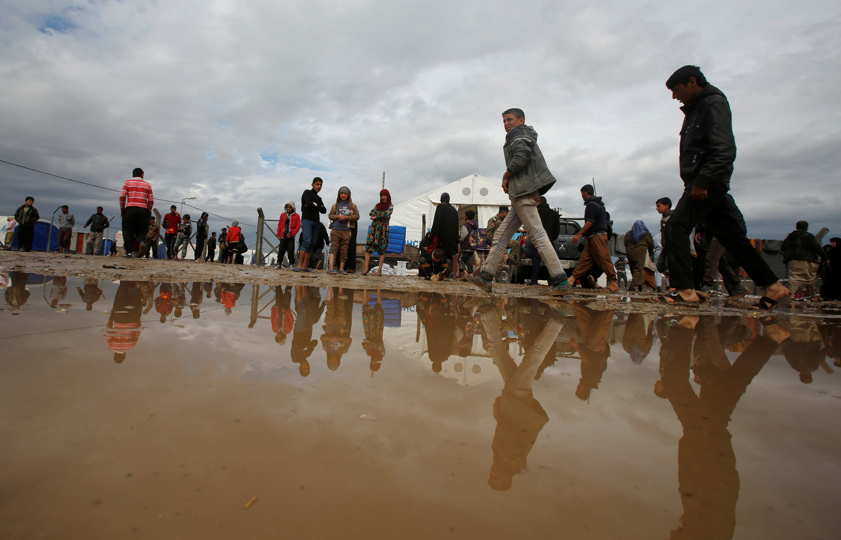 نازحون عراقيون يتحدون مياه الأمطار للوصول إلى المخيمات