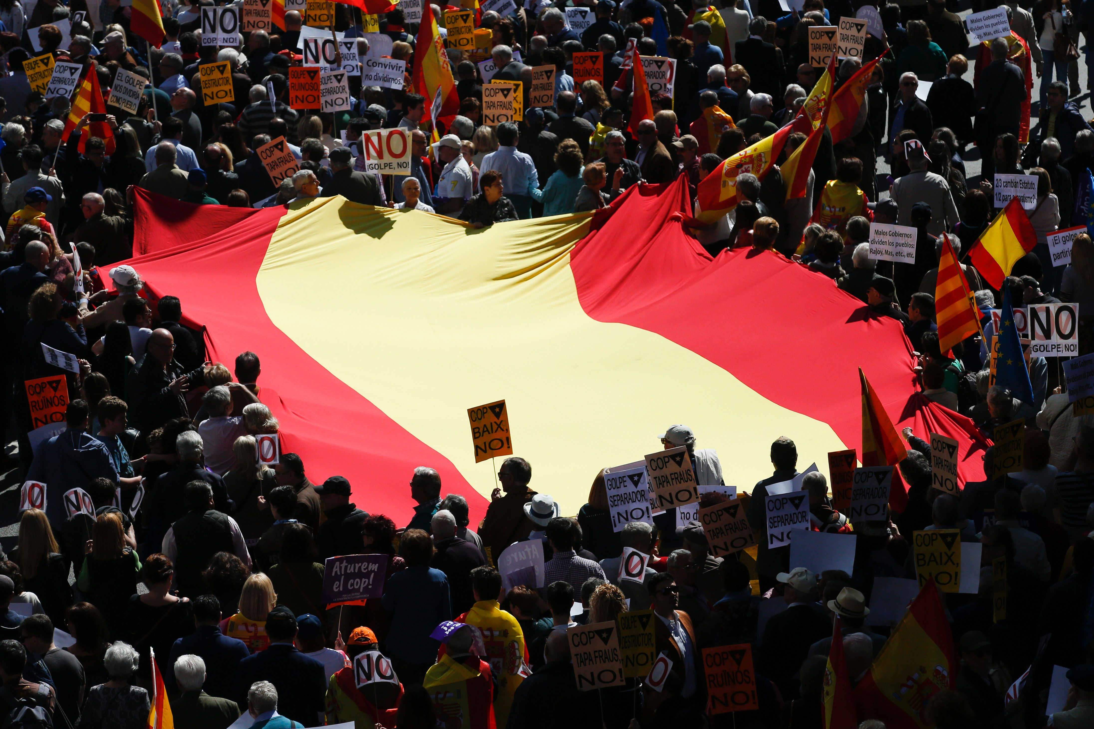 علم إسبانيا مع المتظاهرين خلال الاحتجاج على انفصال كاتالونيا