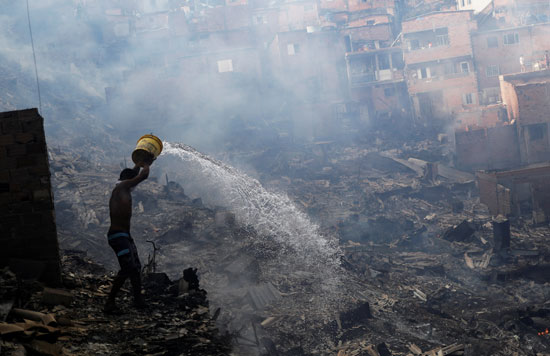  مواطن برازيلى يضخ المياه على الادخنة لإنهاء الحريق ومنعه من الزحف