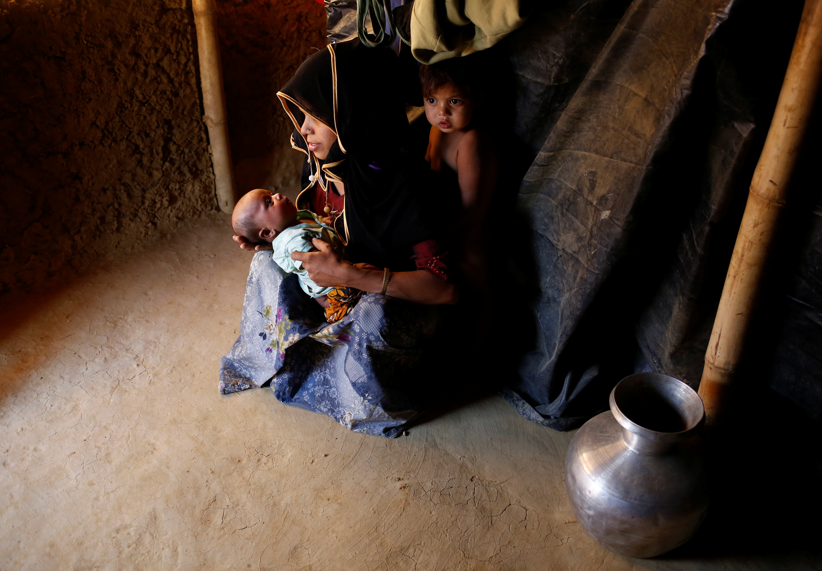 سيدة مع اطفالها داخل مخيم للاجئين