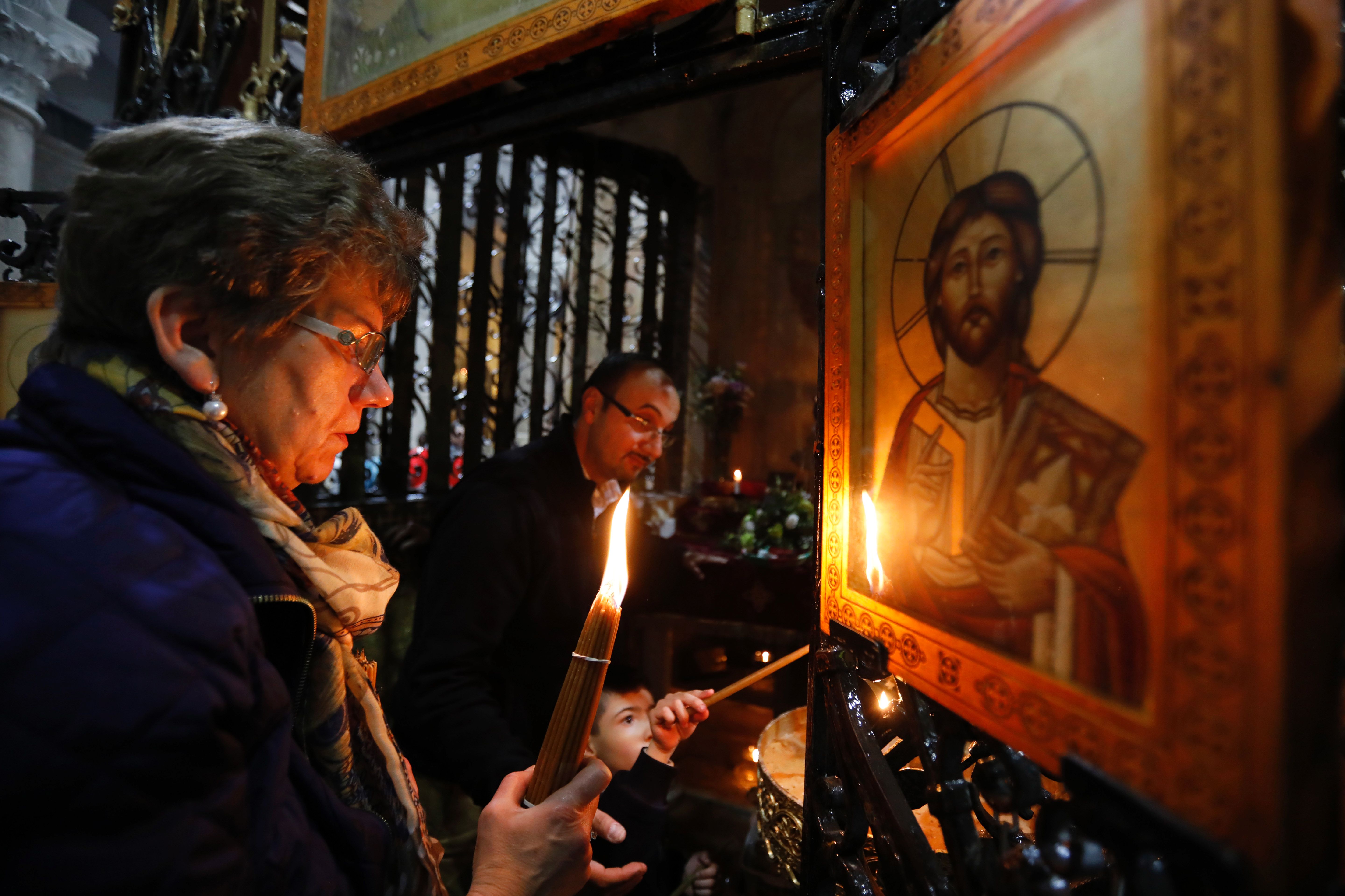 المصلون المسيحيون يشعلون الشموع حول قبر المسيح