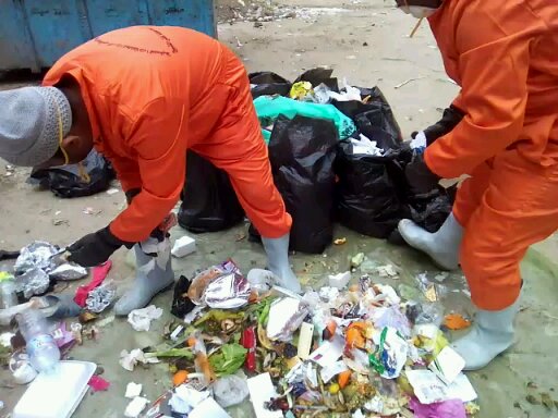 1-العمال يفصلون القمامة بعد استلامها من الأهالي