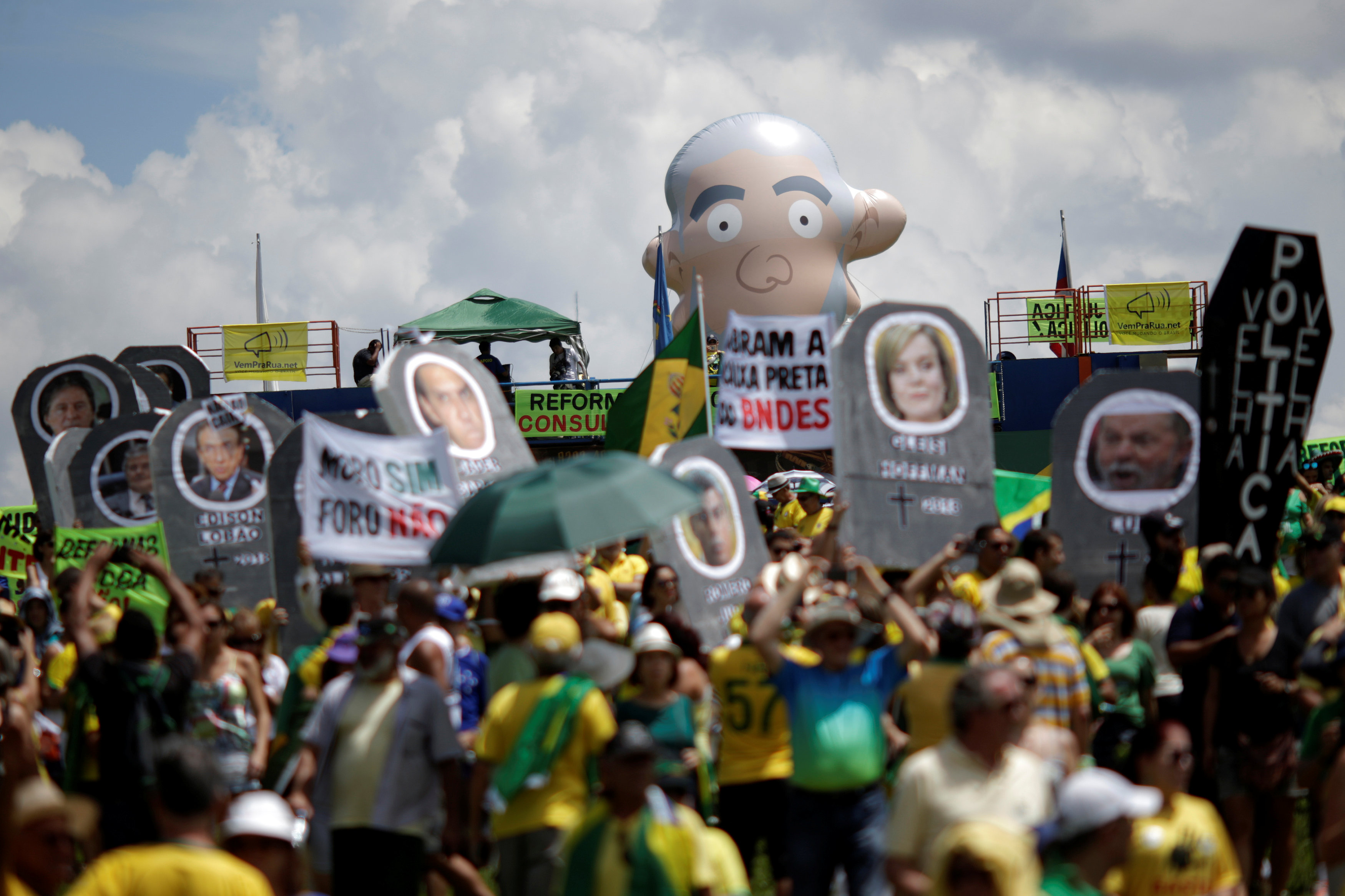 متظاهرون يحملون صورا للسياسيين البرازيليين أثناء احتجاجهم على الفساد