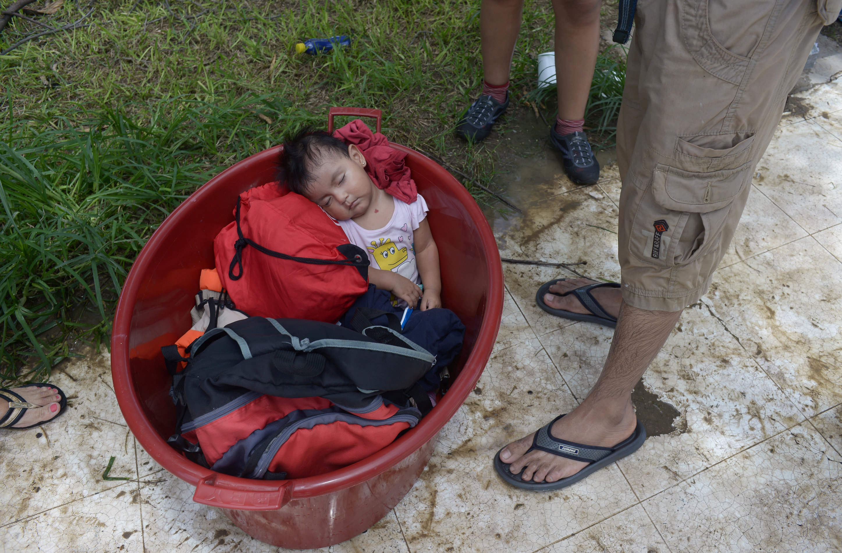طفلة يغلبها النوم بعد عبور مياة الفيضانات