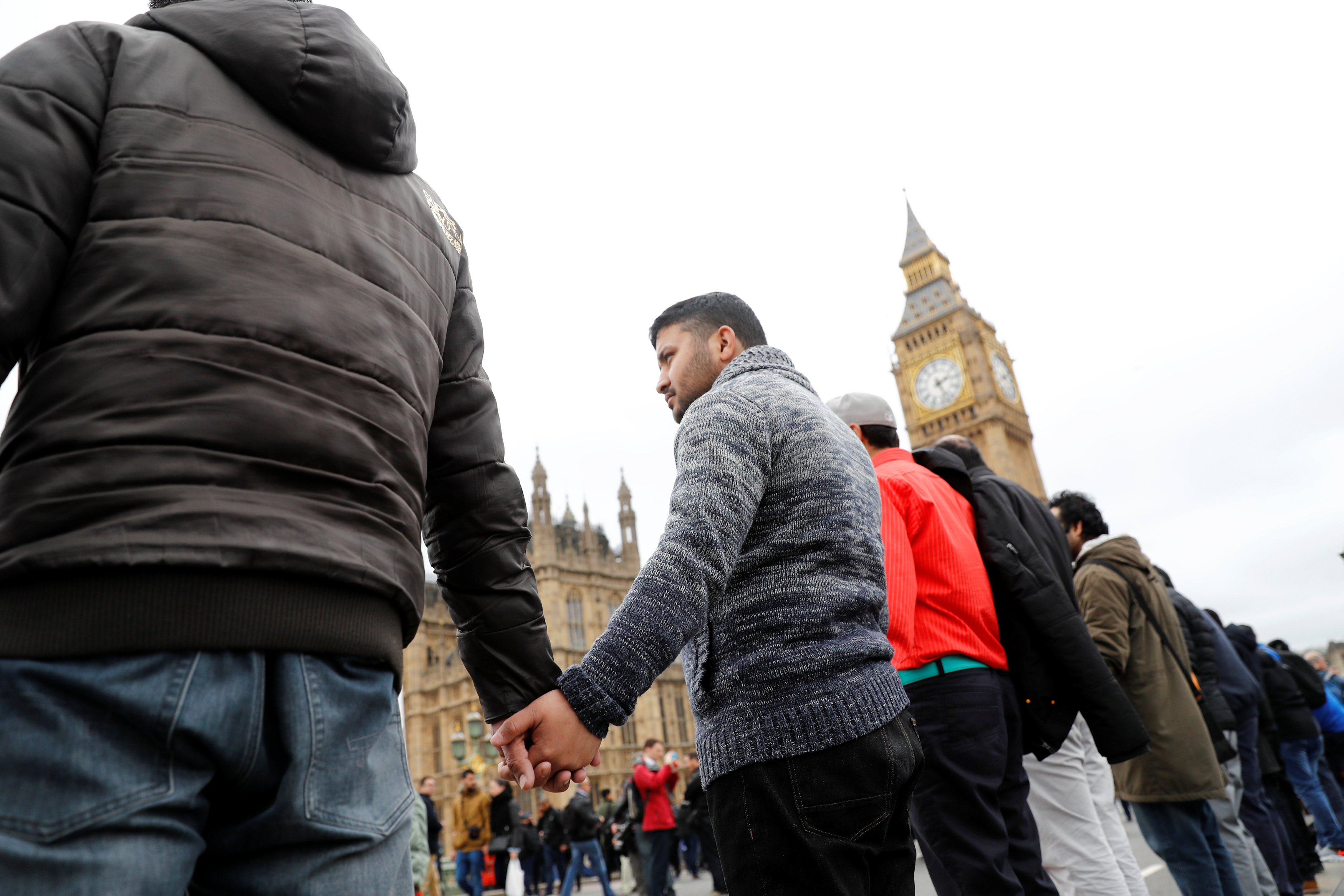 شباب يمسكون أيديهم خلال وقفة فى موقع حادث لندن