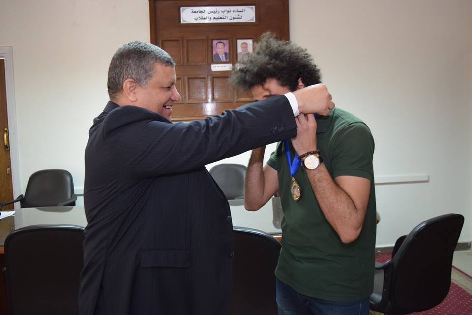 رئيس الجامعة يمنح طالب فائز ميدالية