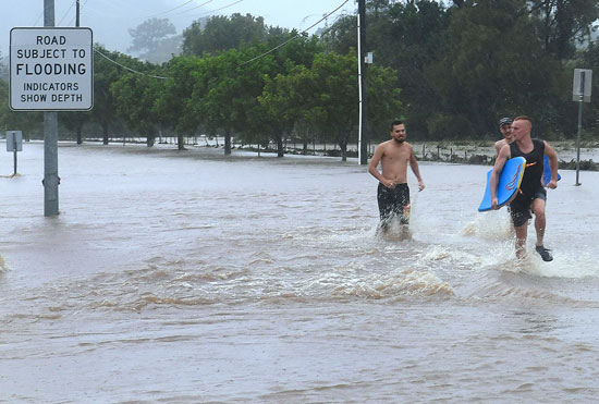 أشخاص يسيرون وسط المياه فى أستراليا