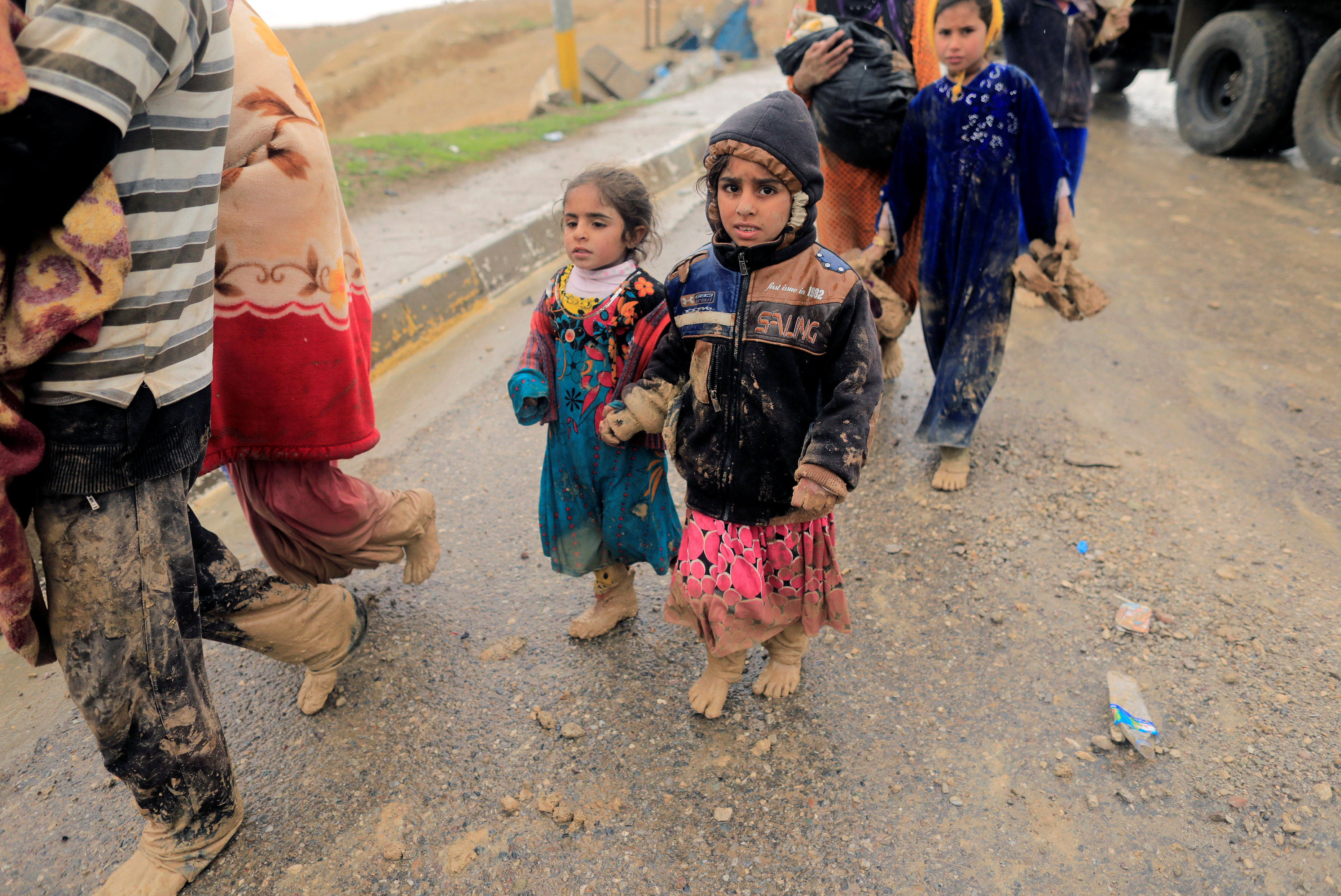 أطفال الموصل يهربون من الاشتباكات رغم هطول الأمطار