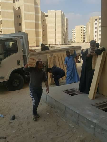 4- عمال  يحملون الاخشباب لتجهيز الوحدات