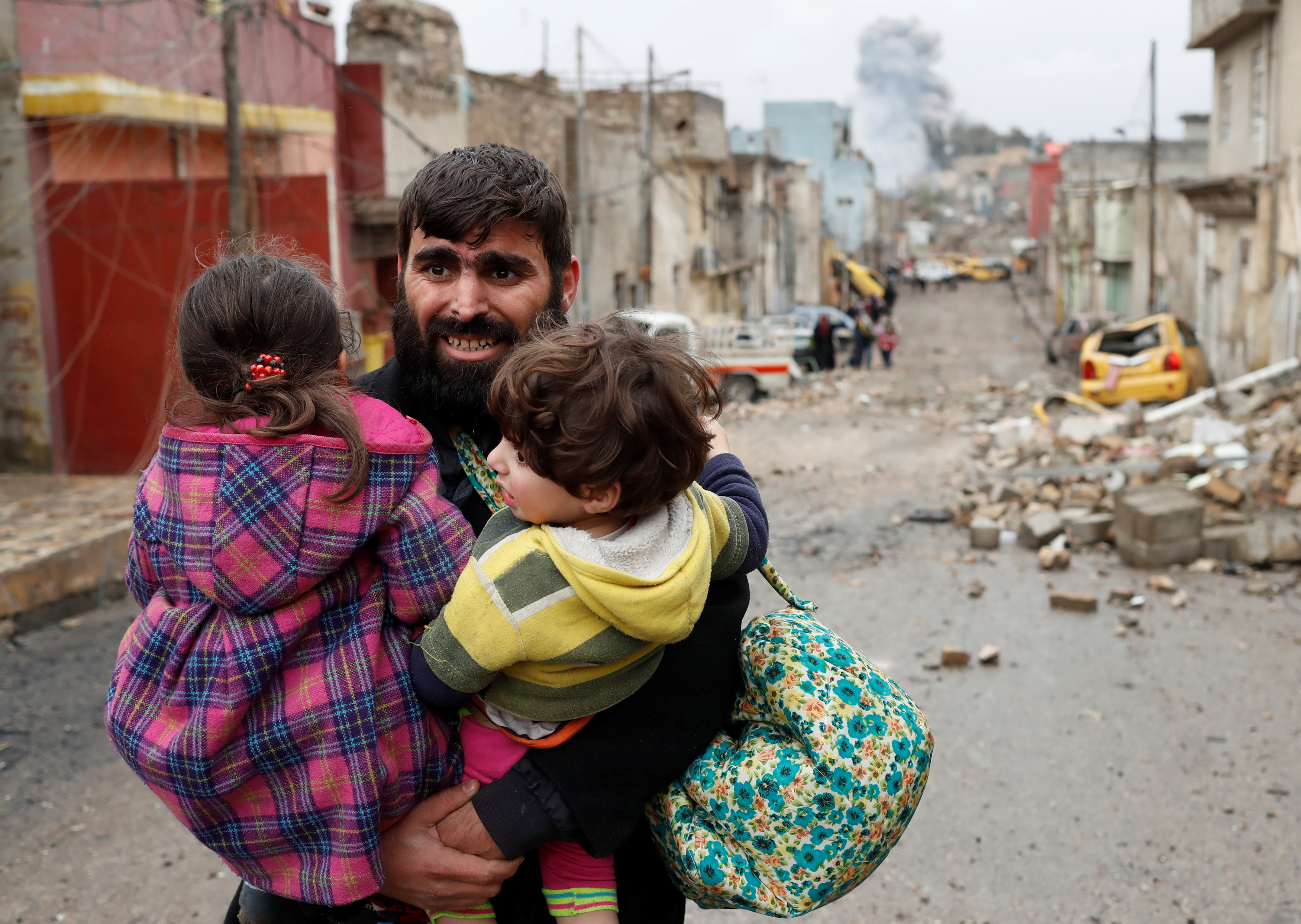 مواطن يحمل طفلين خوفا من القصف العنيف