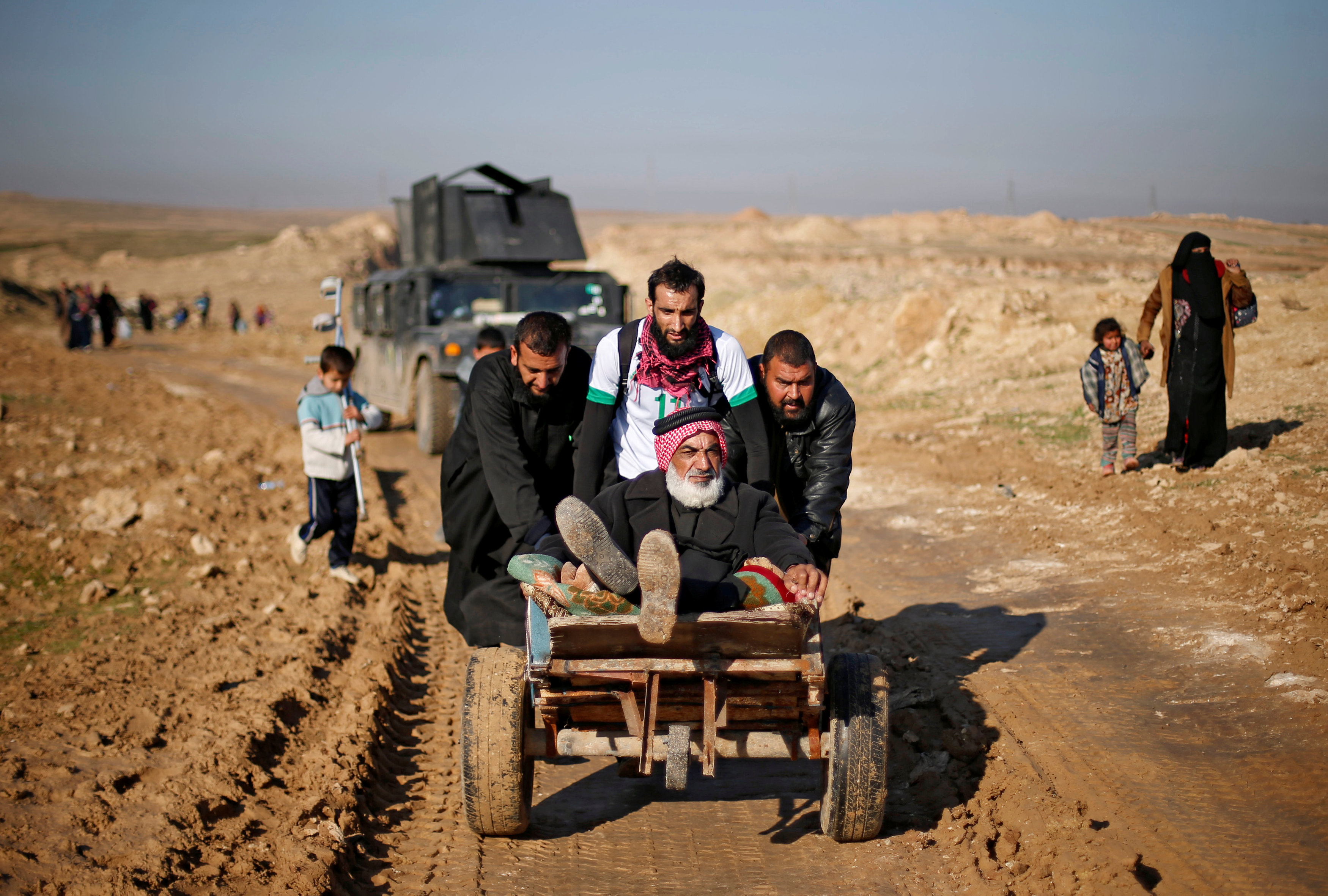 شباب يجرون عربة تحمل رجل مسن فى اتجاه معسكرات القوات العراقية