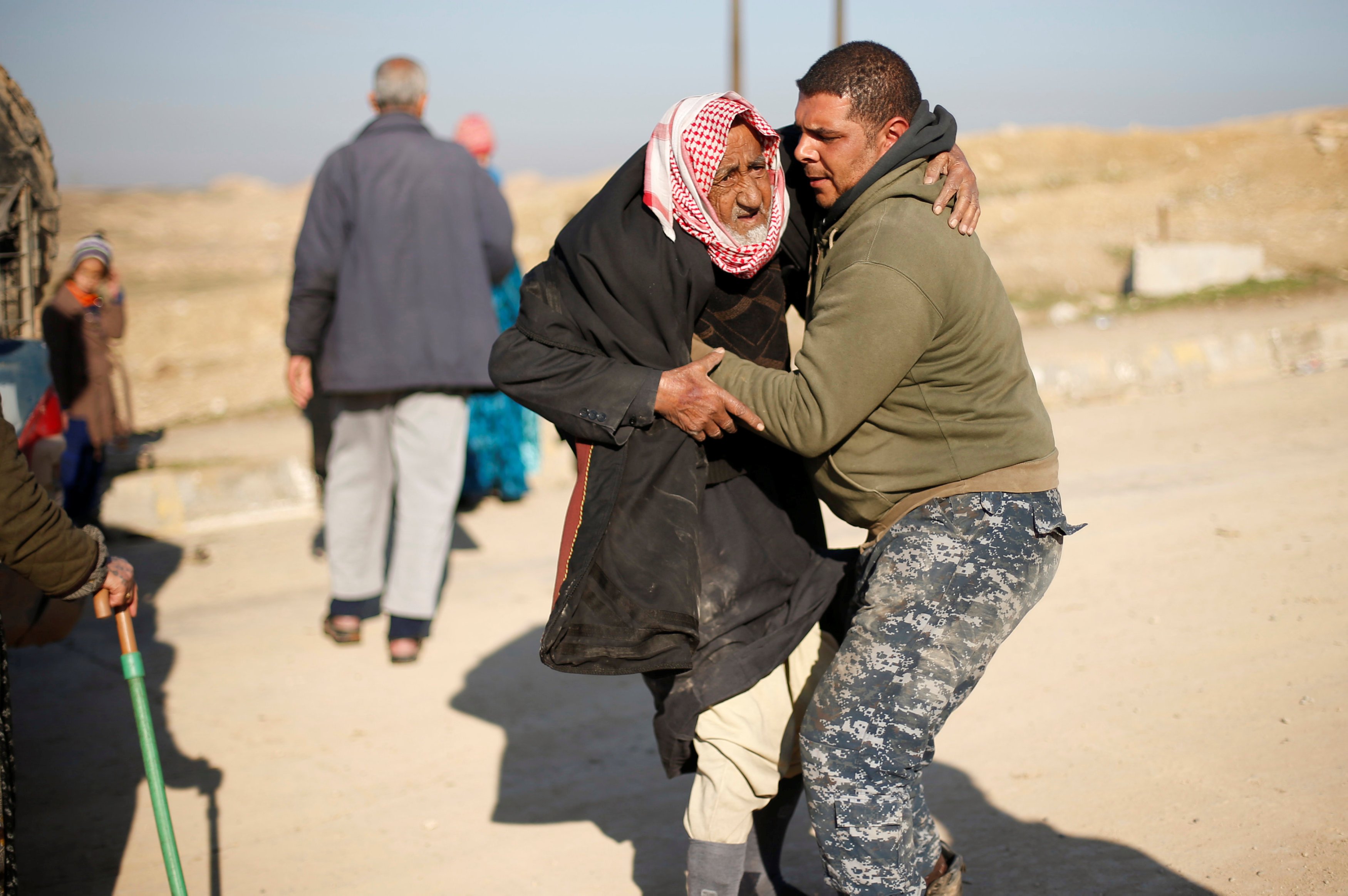 شاب يحمل رجل عجوز نازح من الموصل