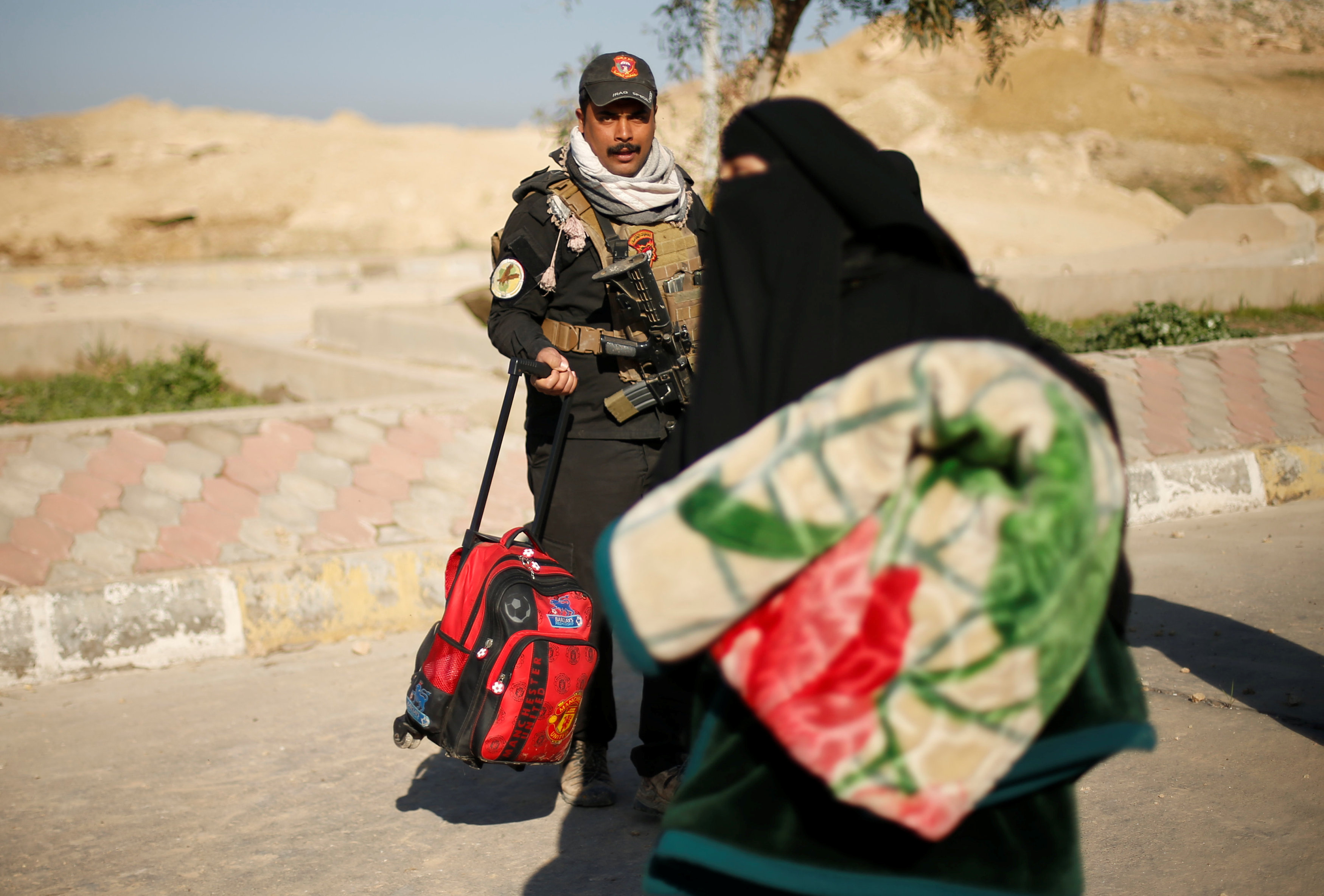 سيدة تحمل بطانية عقب نزوحها من الموصل