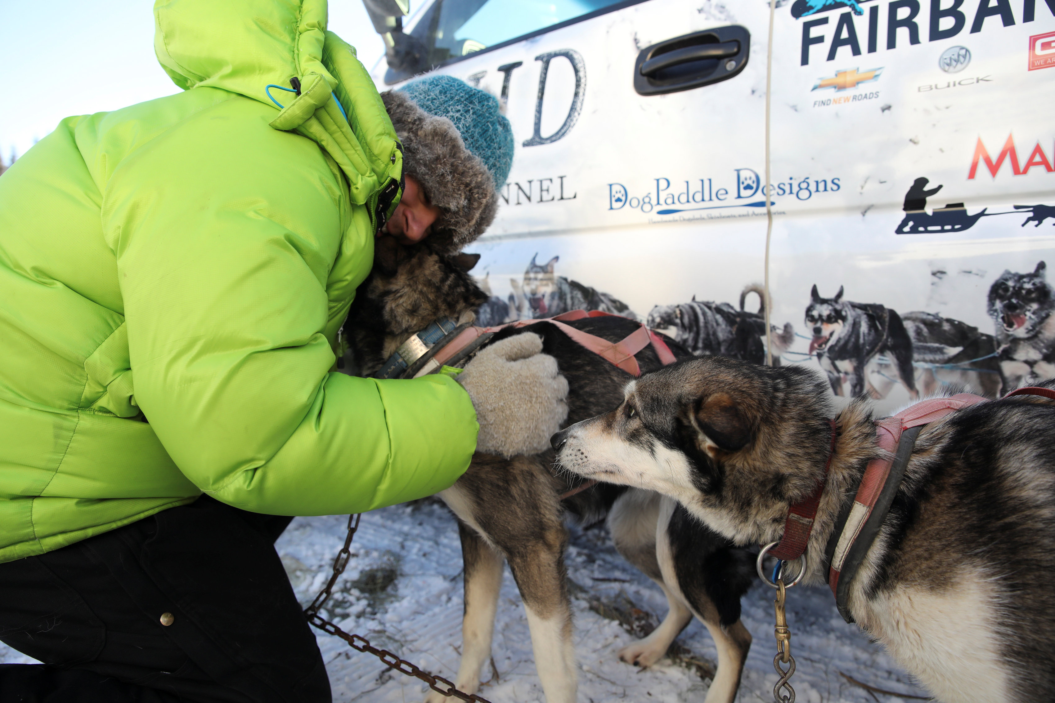 متسابق يحتضن كلابه قبل الانطلاق فى مسابقة التزلج بألاسكا