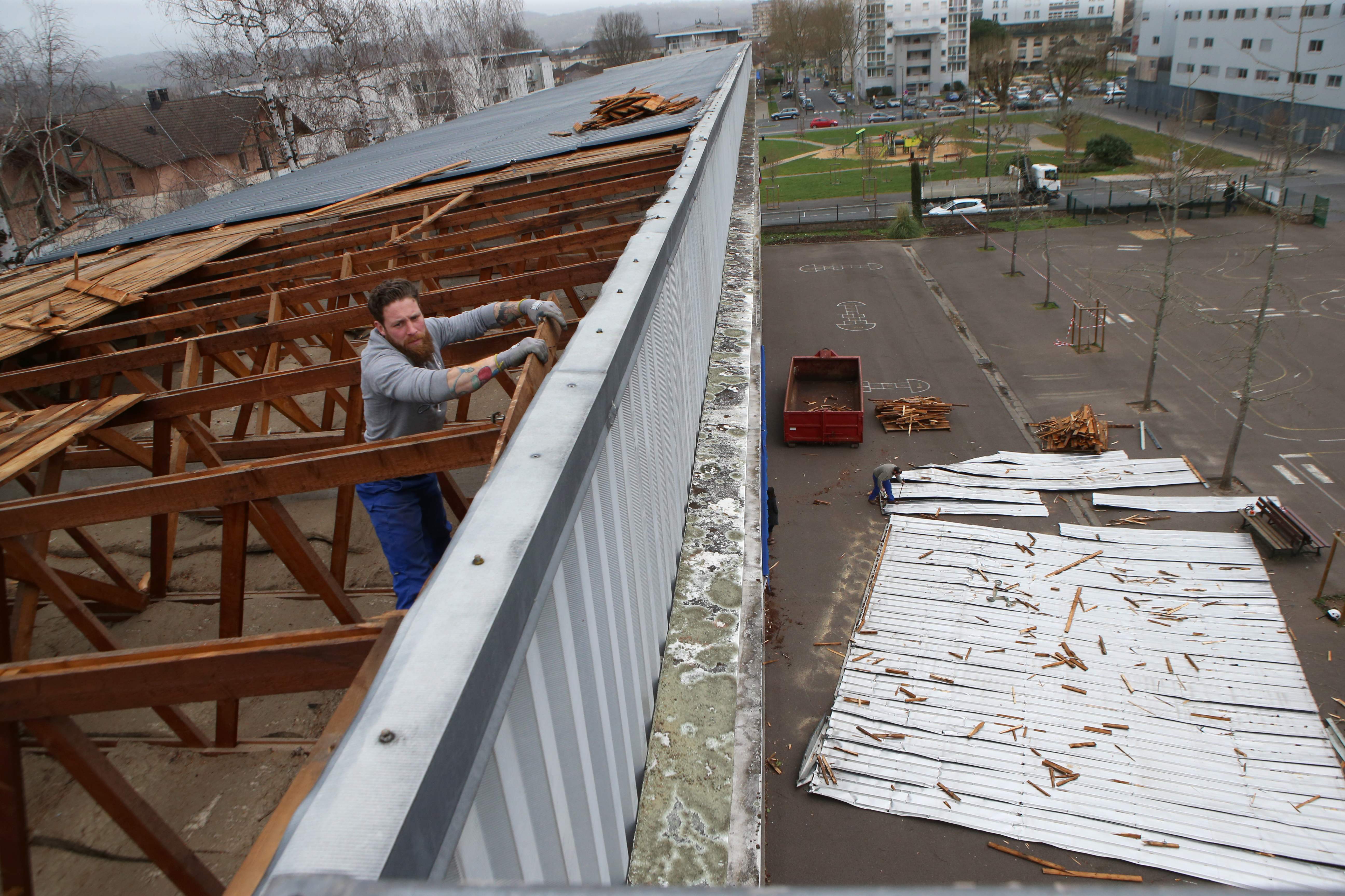 عامل يصلح سقف مدرسة أزالته العاصفة