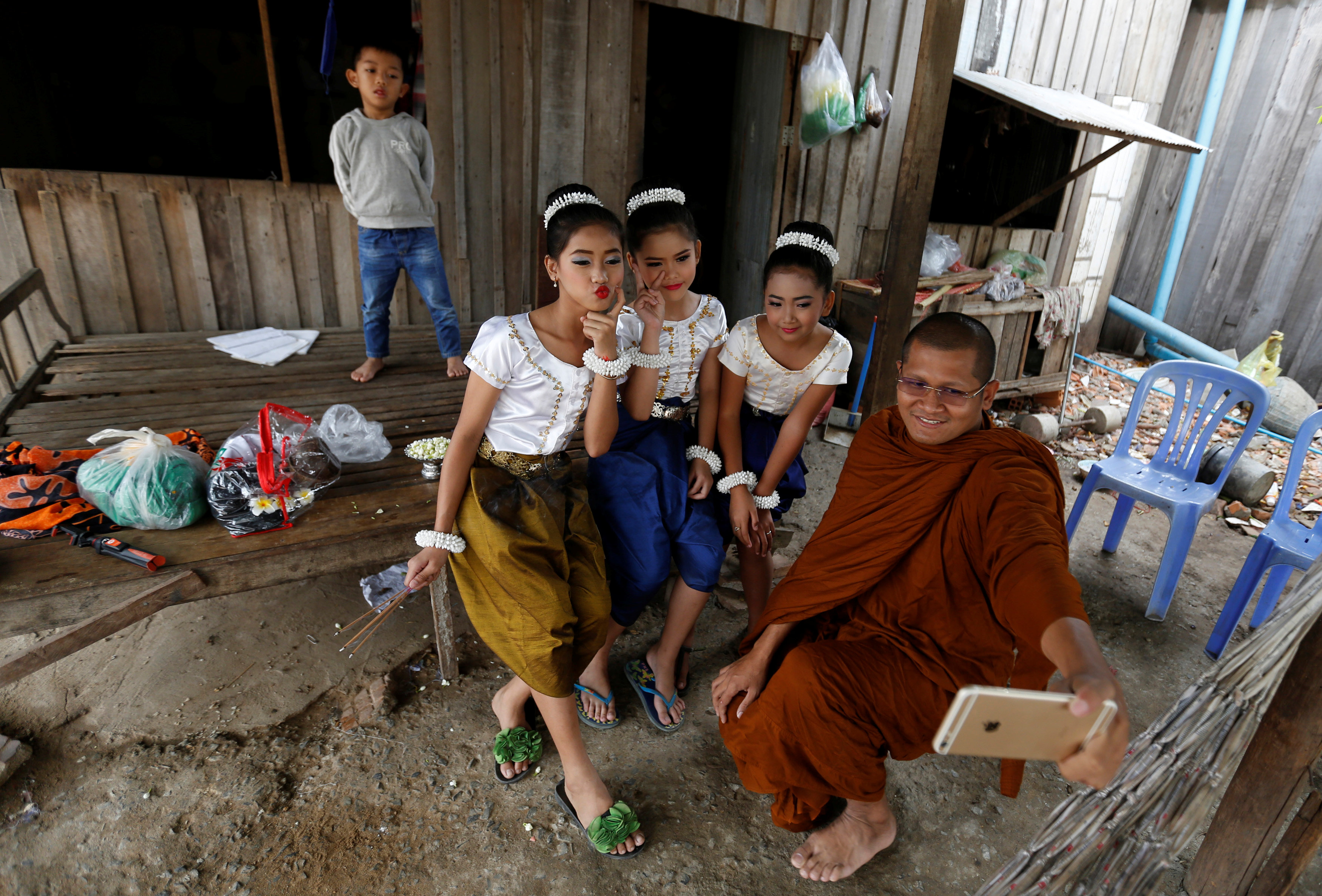 كاهن بوذى يلتقط صورة مع فتيات يستعددن للاحتفال بيوم المرأة