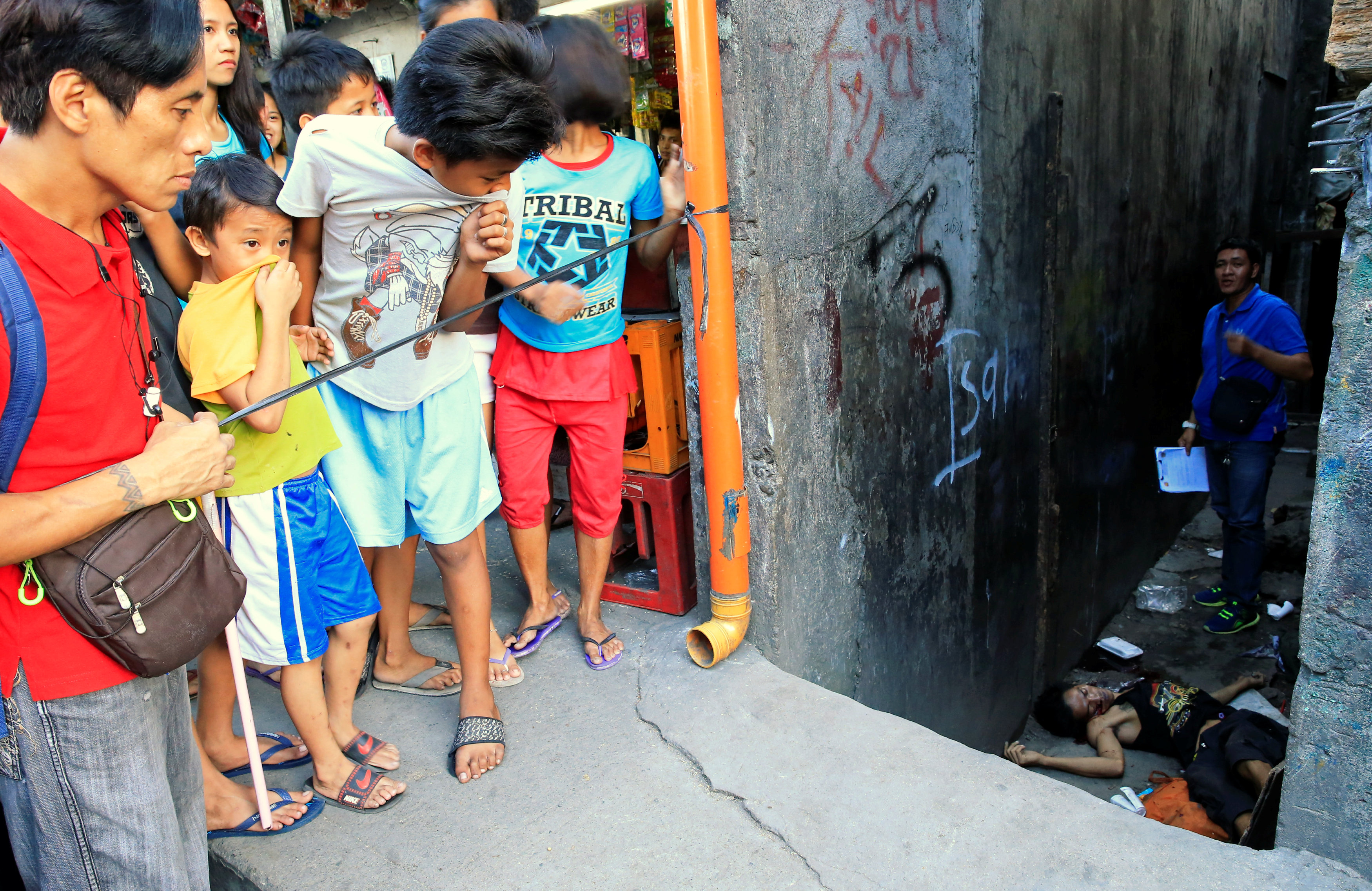 محقق الشرطة الفلبينية يتفقد جثمان تاجر مخدرات مقتول