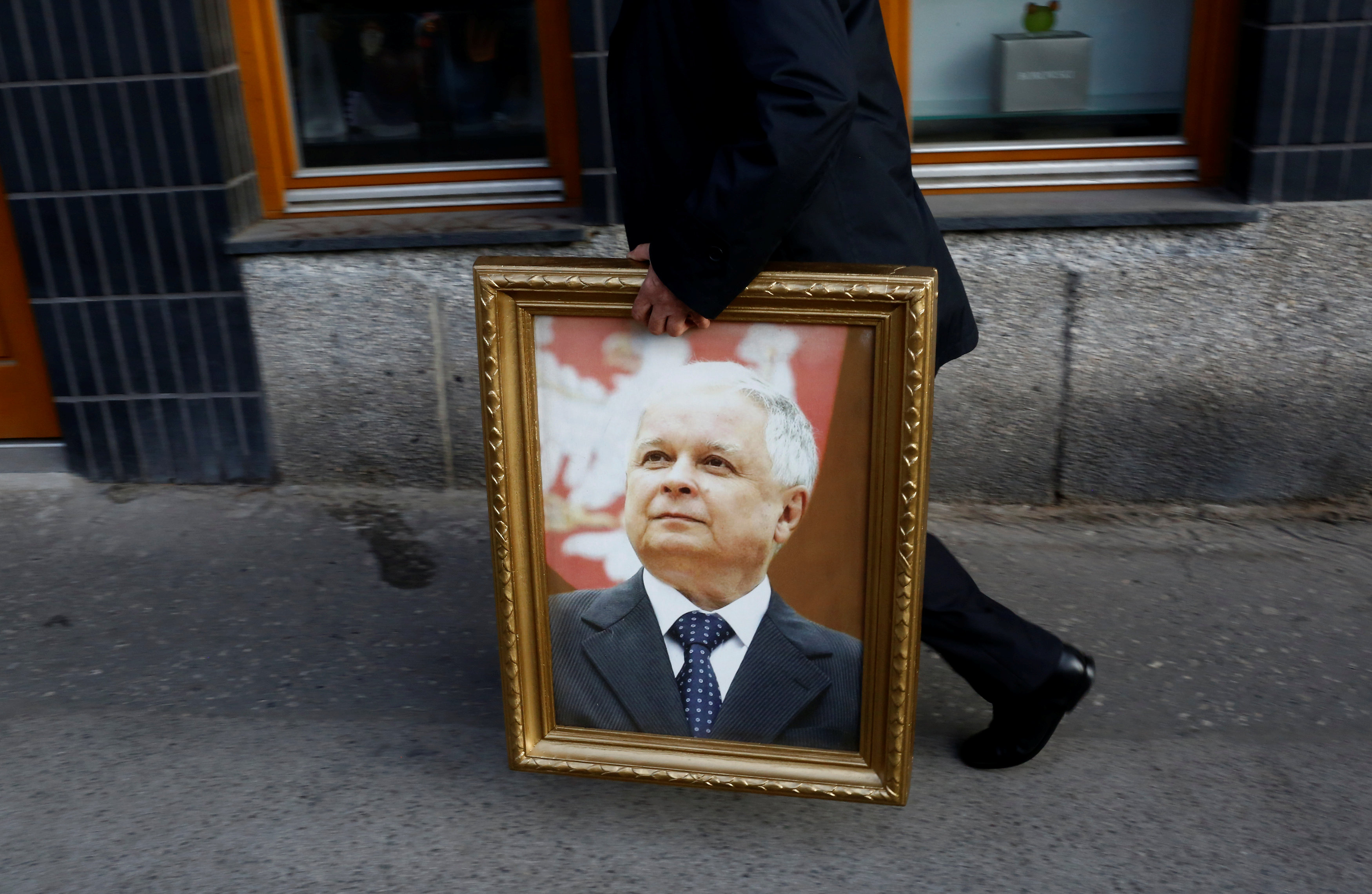 رجل يحمل صورة الرئيس البولندى الراحل قبل المشاركة فى احياء الذكرى