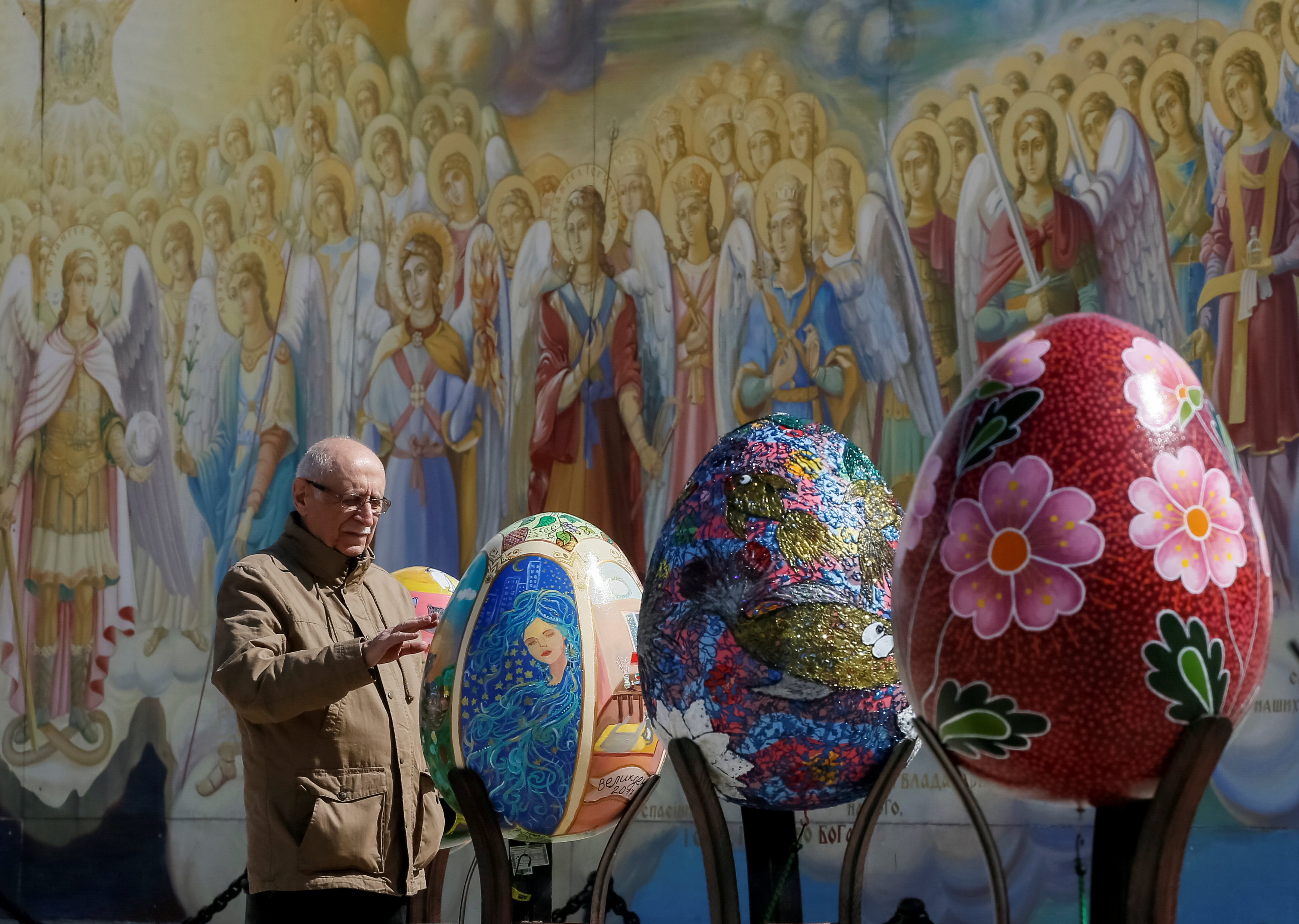 رجل يقف أمام البيض الملون فى احتفالات عيد الفصح بأوكرانيا