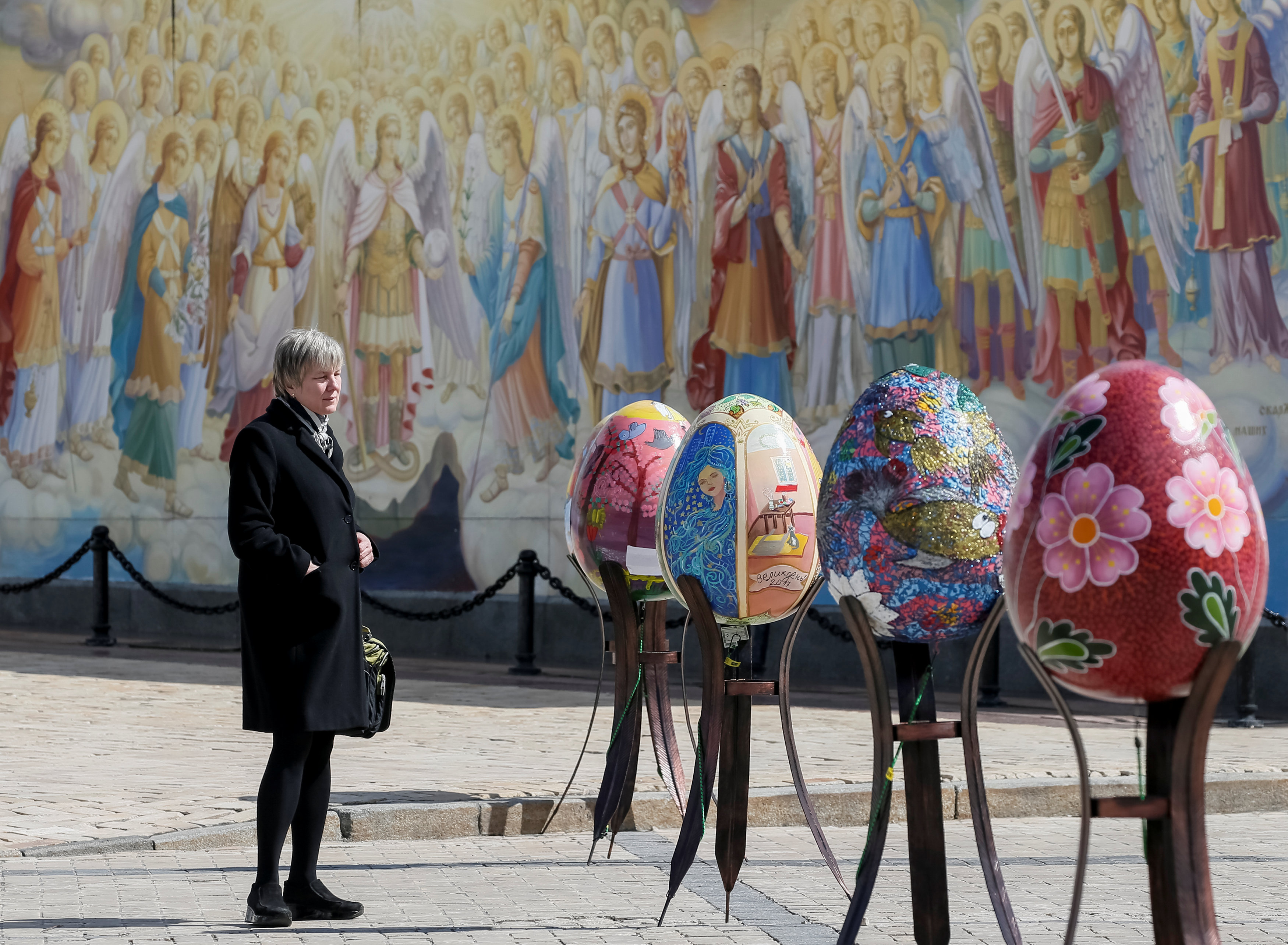 سيدة تقف أمام البيض الملون فى كييف