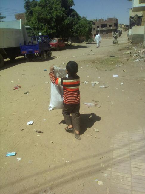 طفل يساعد فى جمع القمامة